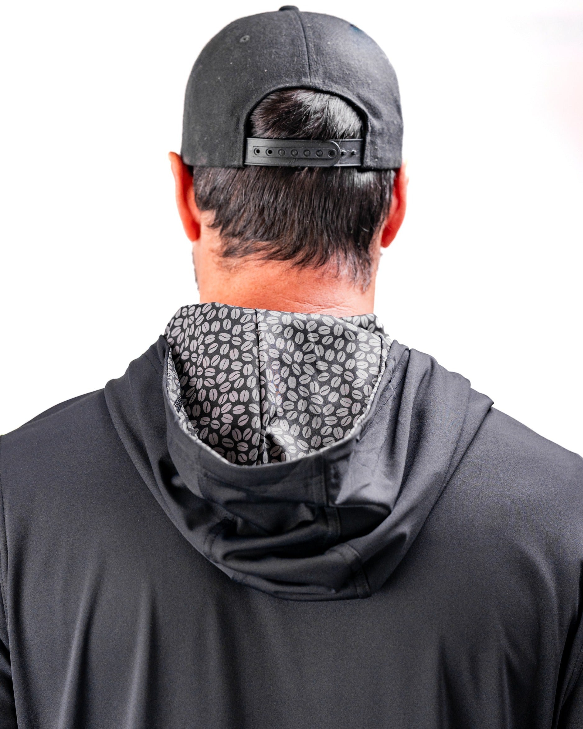 Men's performance golf hoodie in black with a coffee bean patterned lining, designed for comfort and style on the course.