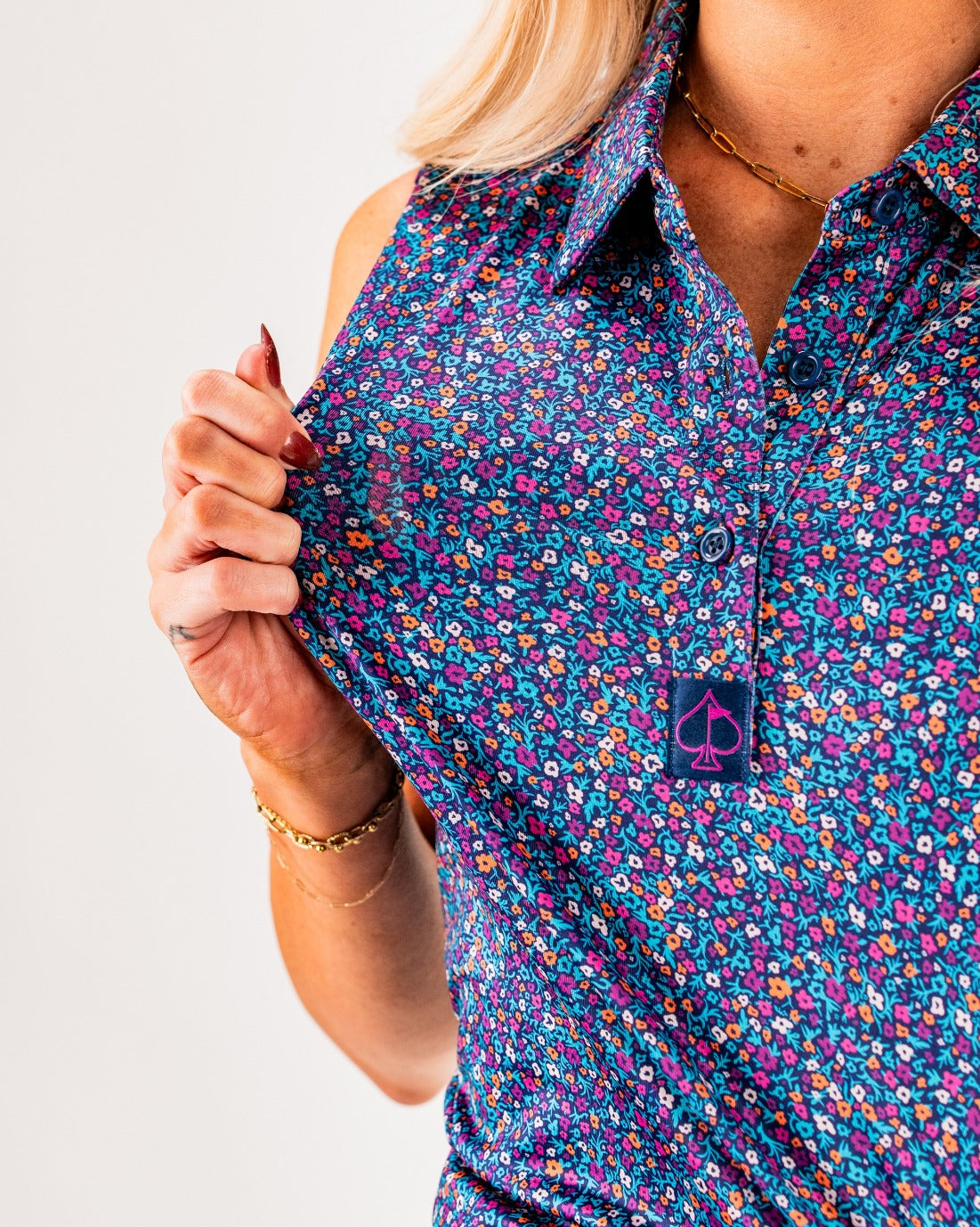 Women's Lavender Flower Power golf shirt featuring a vibrant floral pattern and a stylish logo on the collar.