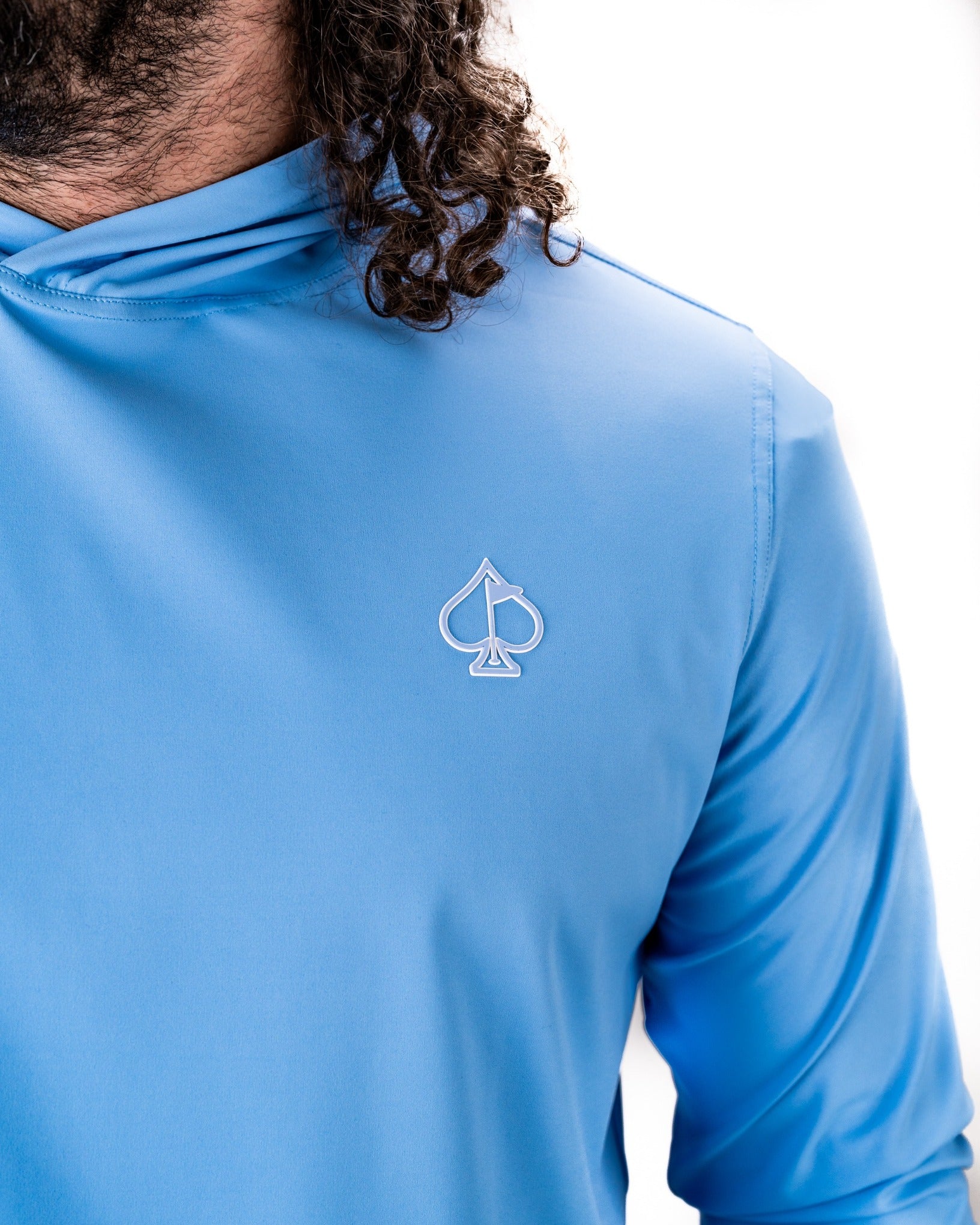 Light blue performance golf hoodie featuring a stylish spade logo, designed for comfort and style on the course.