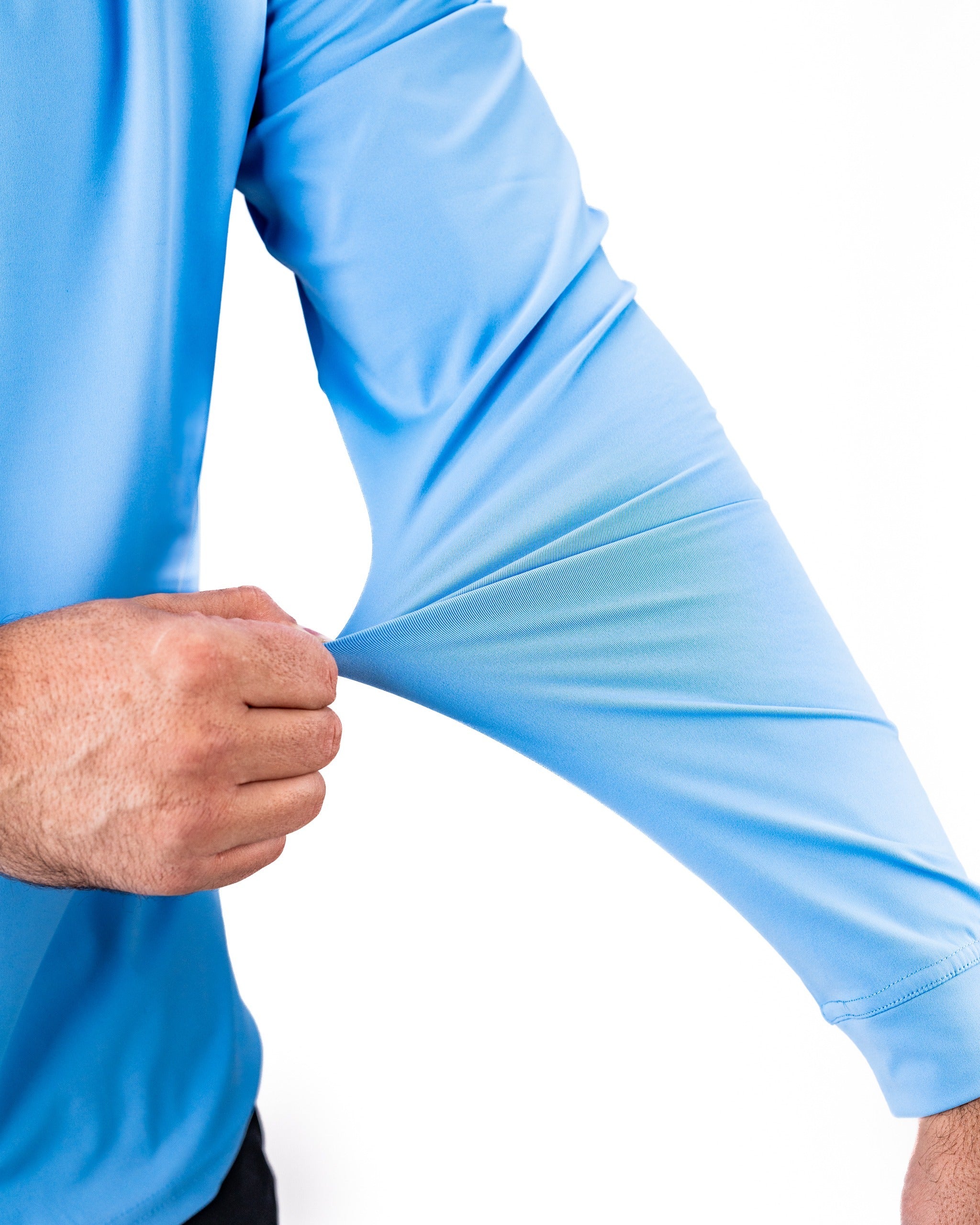 Light blue Performance Golf Hoodie with a close-up of a hand pulling the sleeve, showcasing its stretchable fabric.