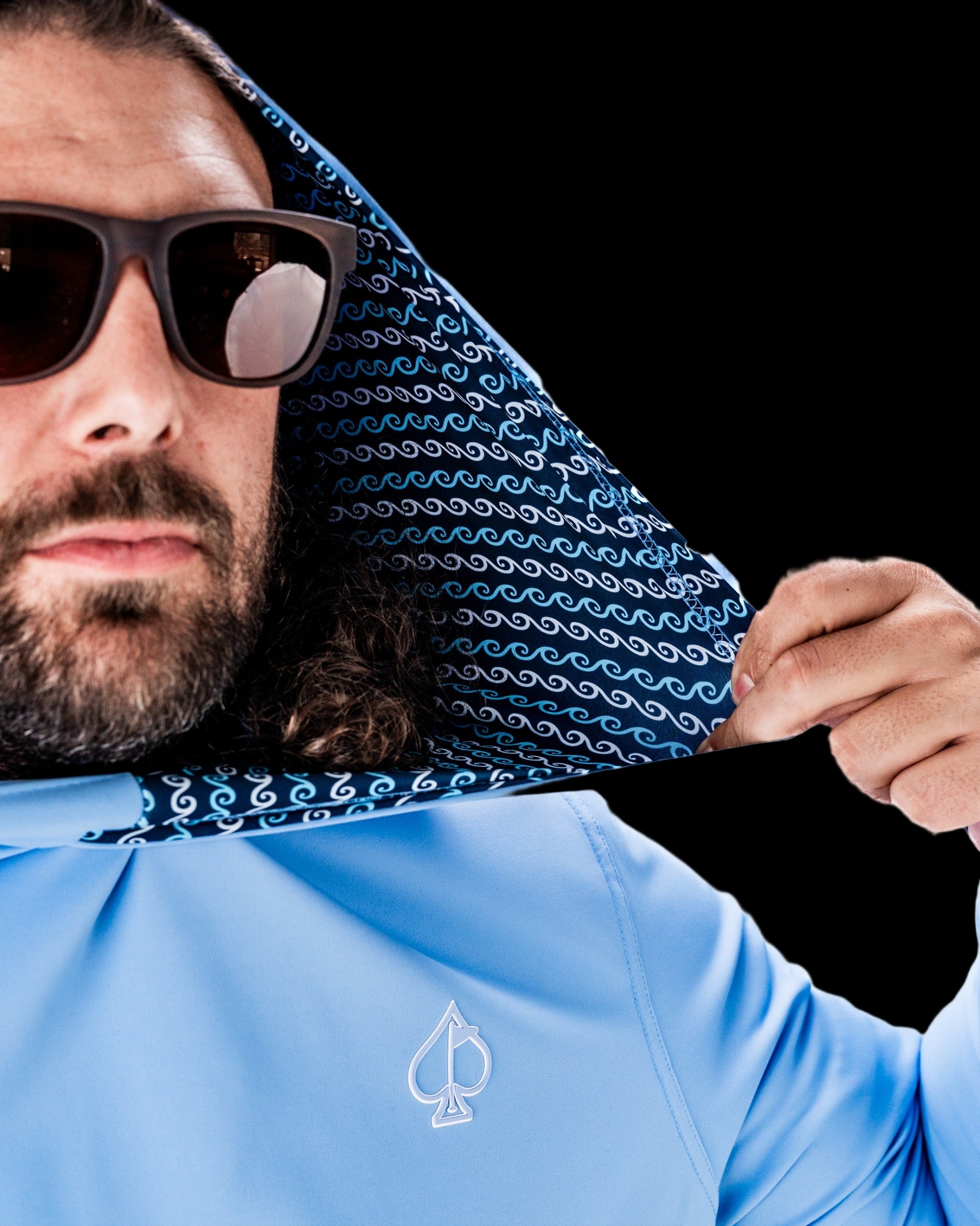 Performance Golf Hoodie in light blue with a patterned hood, worn by a man in sunglasses, showcasing a stylish and functional design.