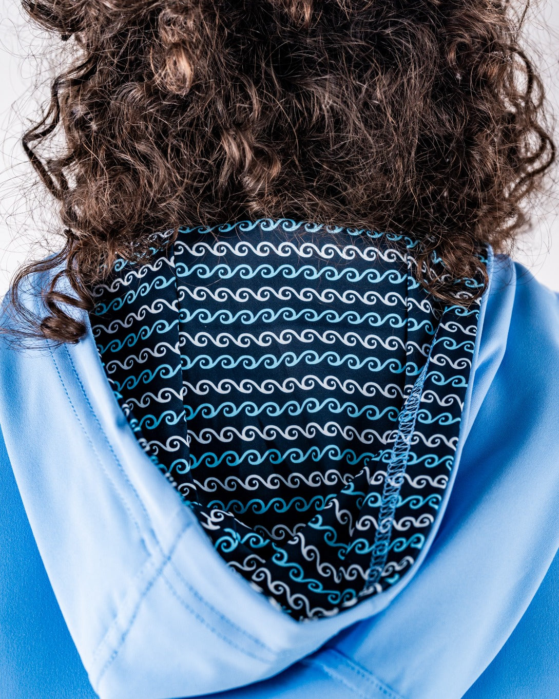 Performance Golf Hoodie - Rising Tides 2.0 features a stylish hood with a wave pattern lining, perfect for golfers seeking comfort and style.