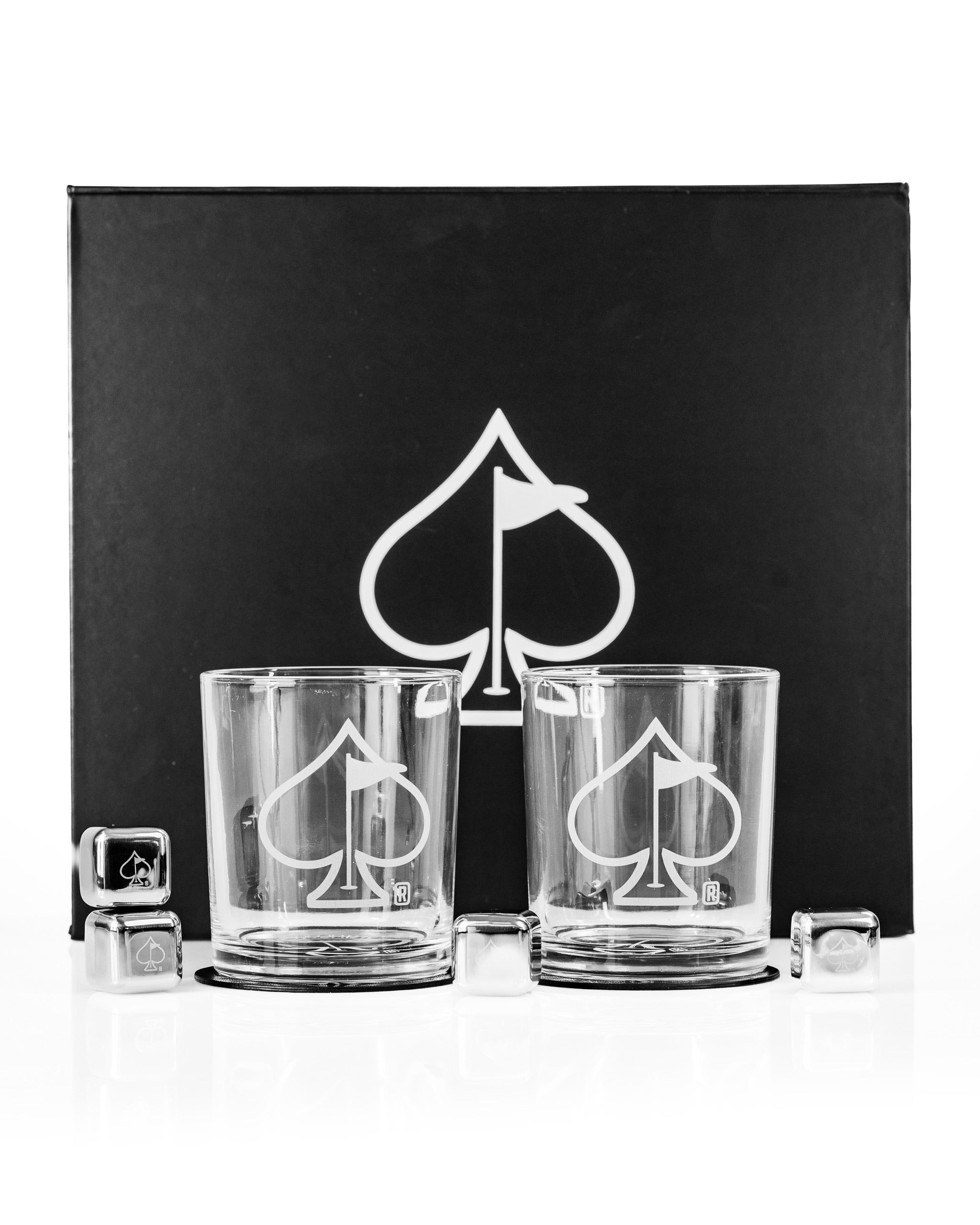 Set of two whisky glasses featuring a spade logo, presented in a sleek black box with ice cubes. Perfect for gifting.