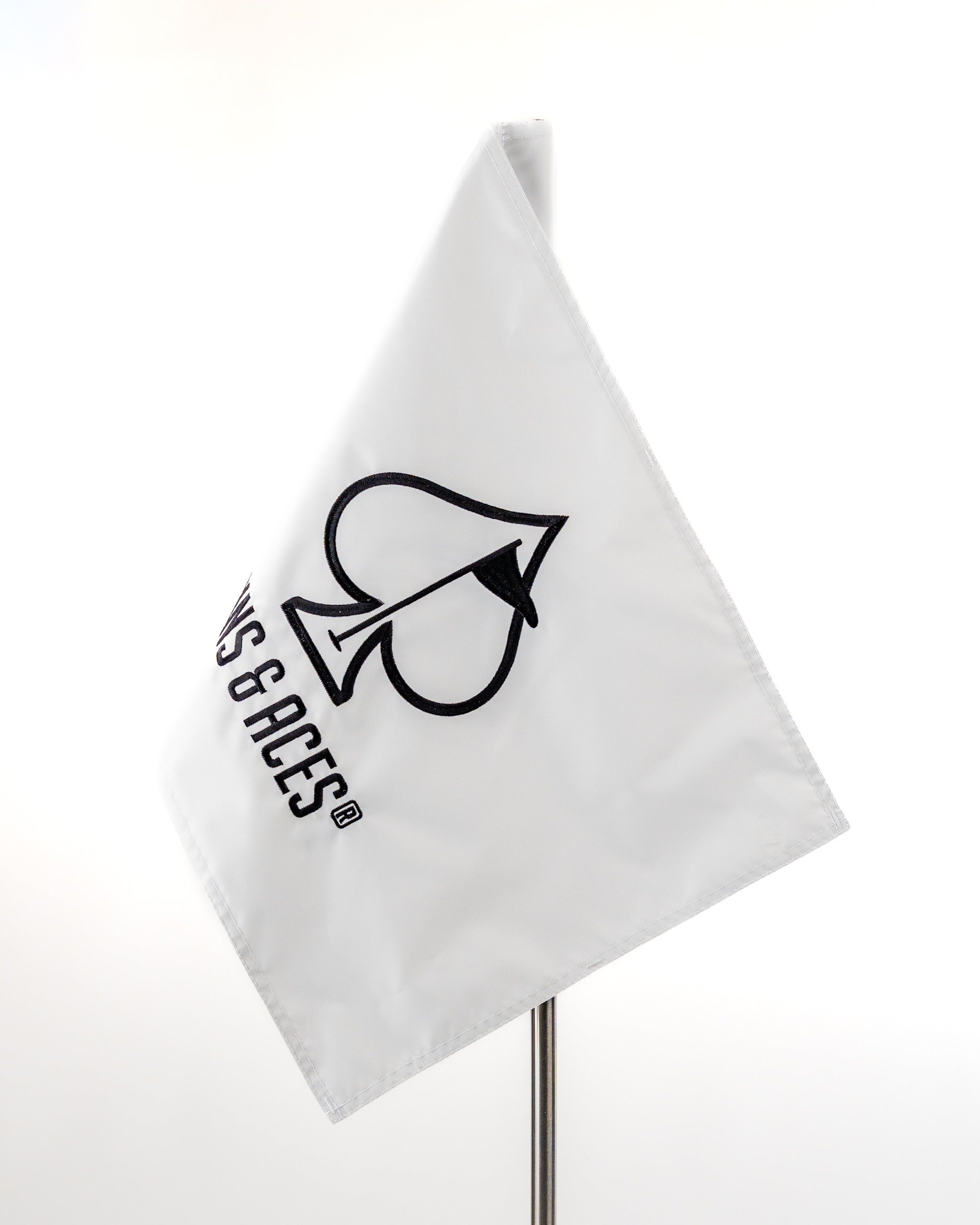 White golf flag featuring the Pins and Aces logo, designed for golfers seeking stylish course accessories.