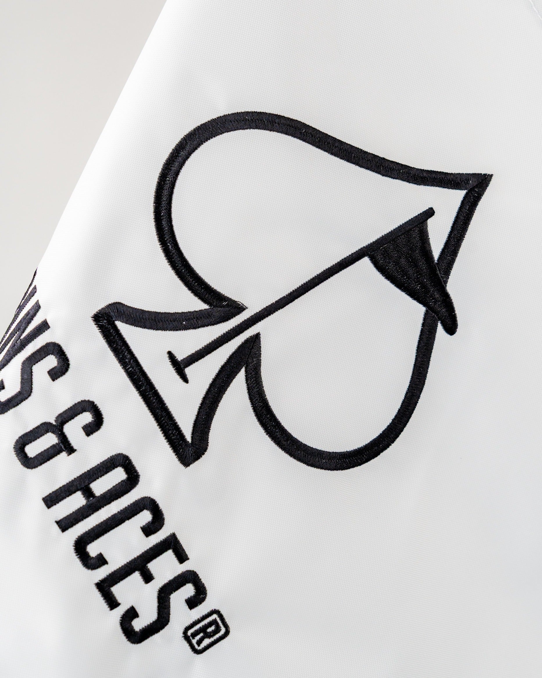 Bold golf flag featuring a prominent spade logo and "Pins & Aces" branding, perfect for stylish golfers.