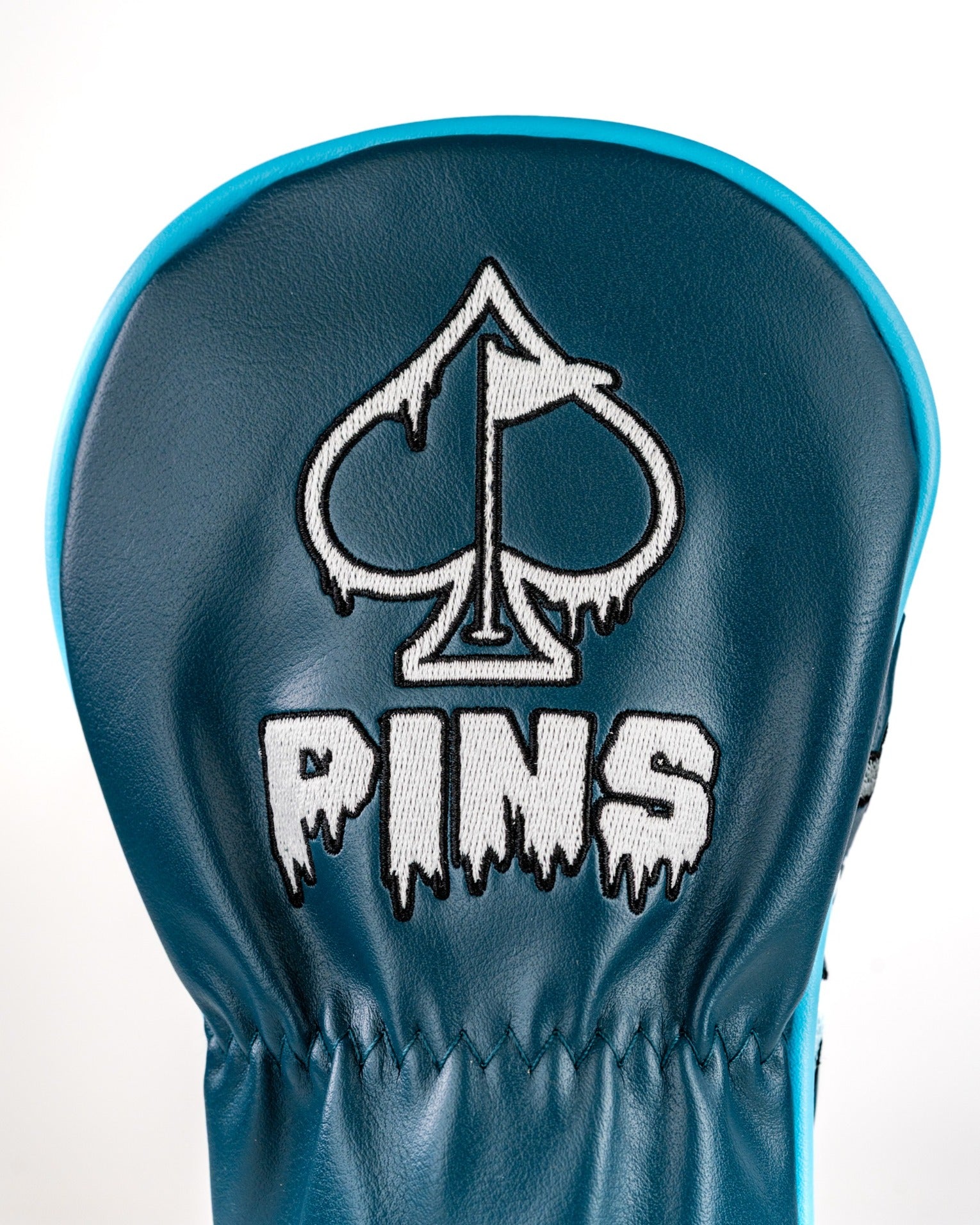 Snowman fairway cover featuring a bold design with a spade logo and "PINS" in a dripping font, perfect for stylish golfers.