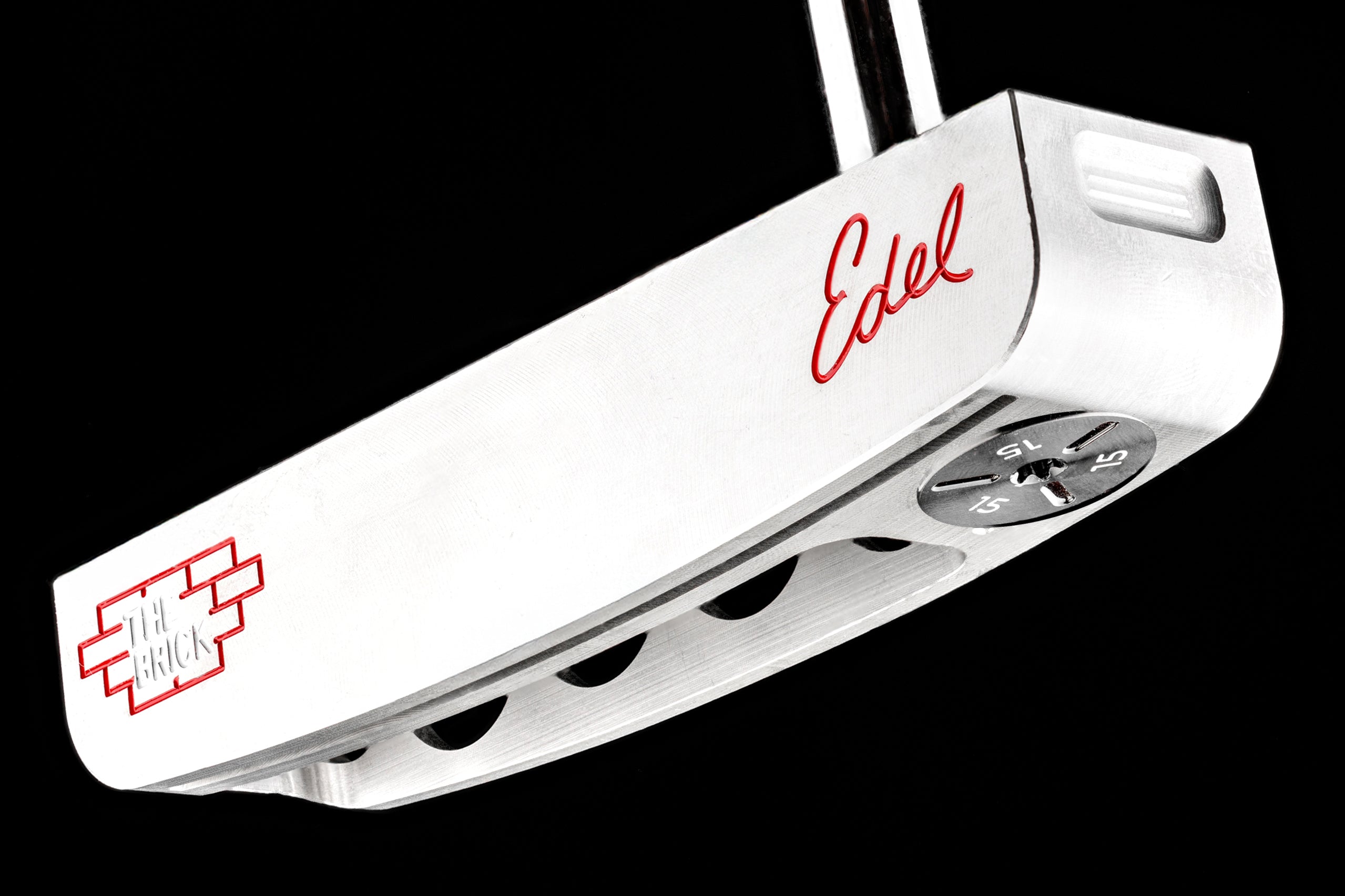 Edel Golf's The Brick blade putter features a sleek silver design with a unique alignment aid and adjustable weights.