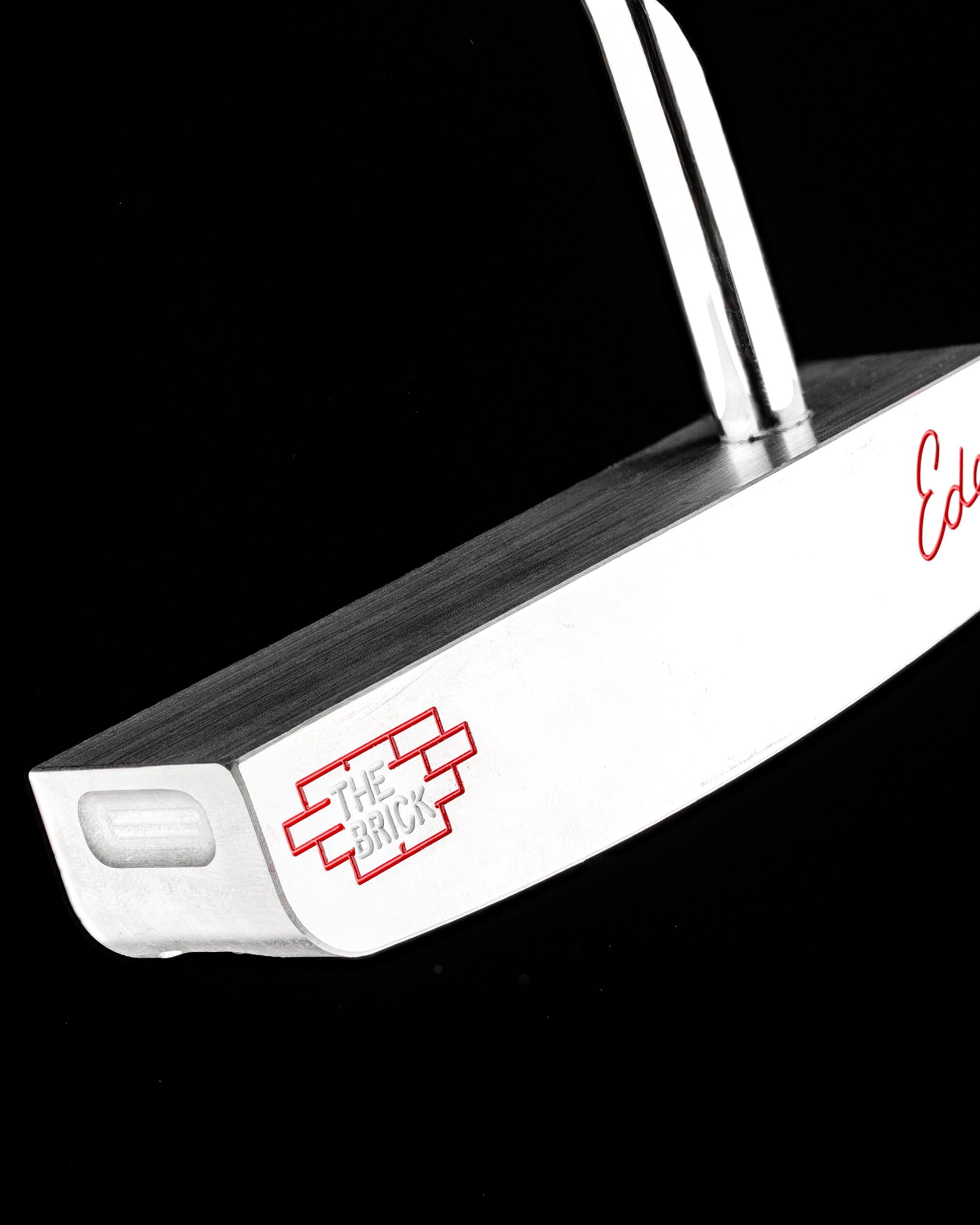 Sleek blade putter by Edel Golf, featuring a polished finish and "The Brick" logo for precision and style on the green.