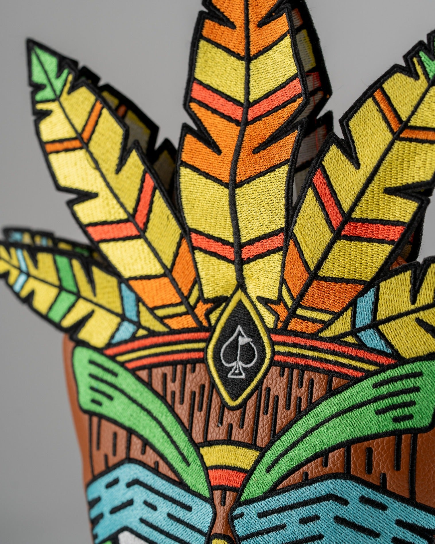 Colorful Tiki driver cover featuring vibrant embroidered feathers and a unique design, perfect for bold golfers.