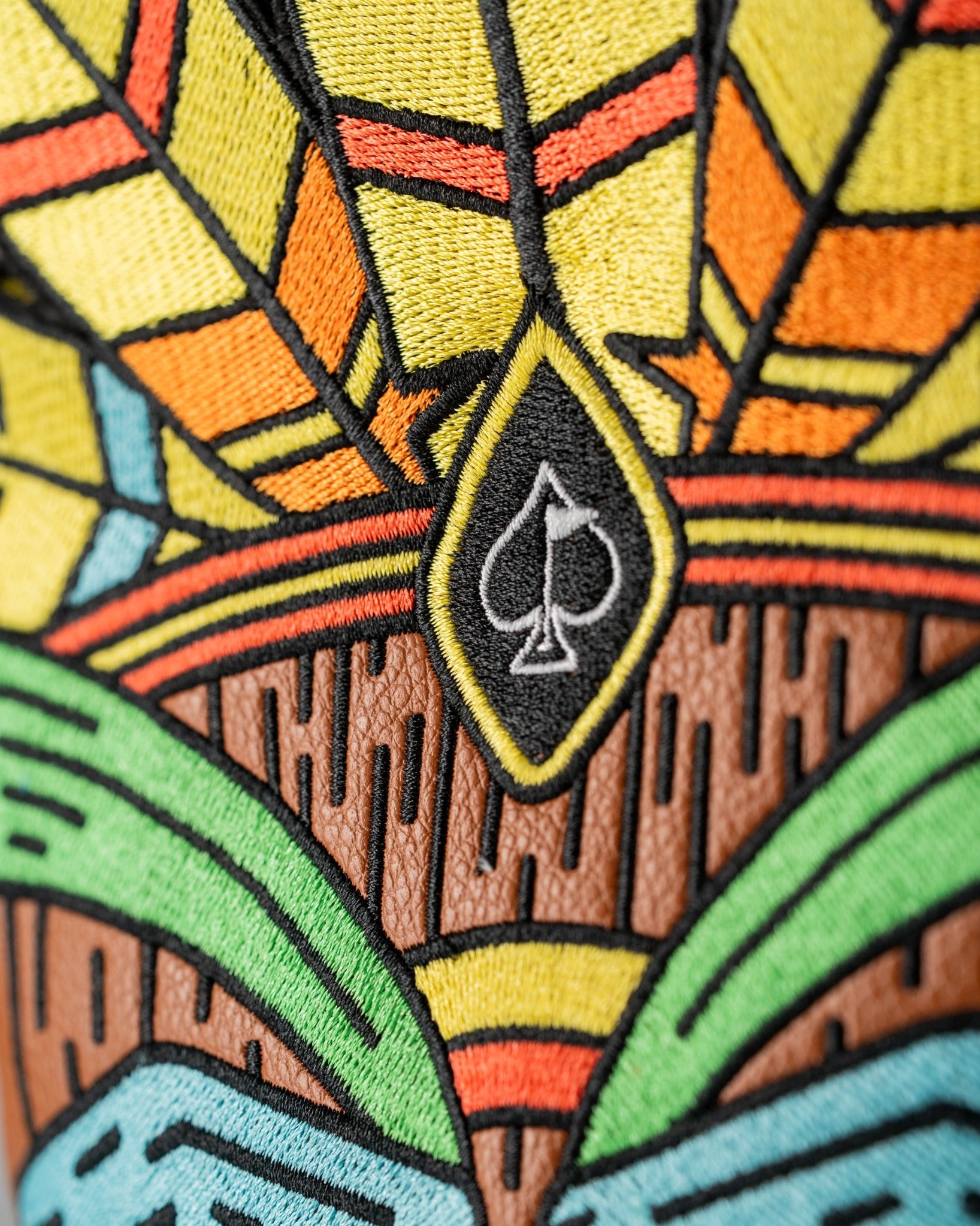 Colorful Tiki driver cover featuring vibrant embroidery with tropical patterns and a spade logo, perfect for stylish golfers.