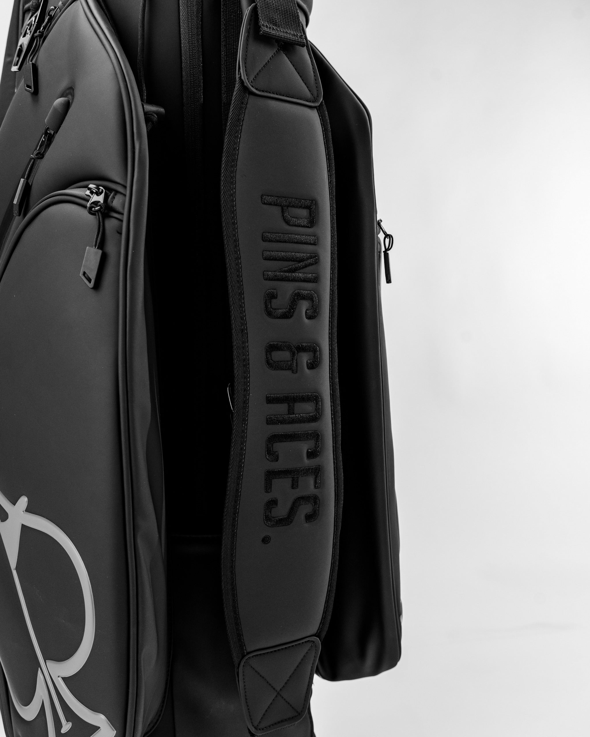 Sleek black Player Preferred™ Cart Bag featuring padded strap with Pins and Aces branding for stylish golf storage.