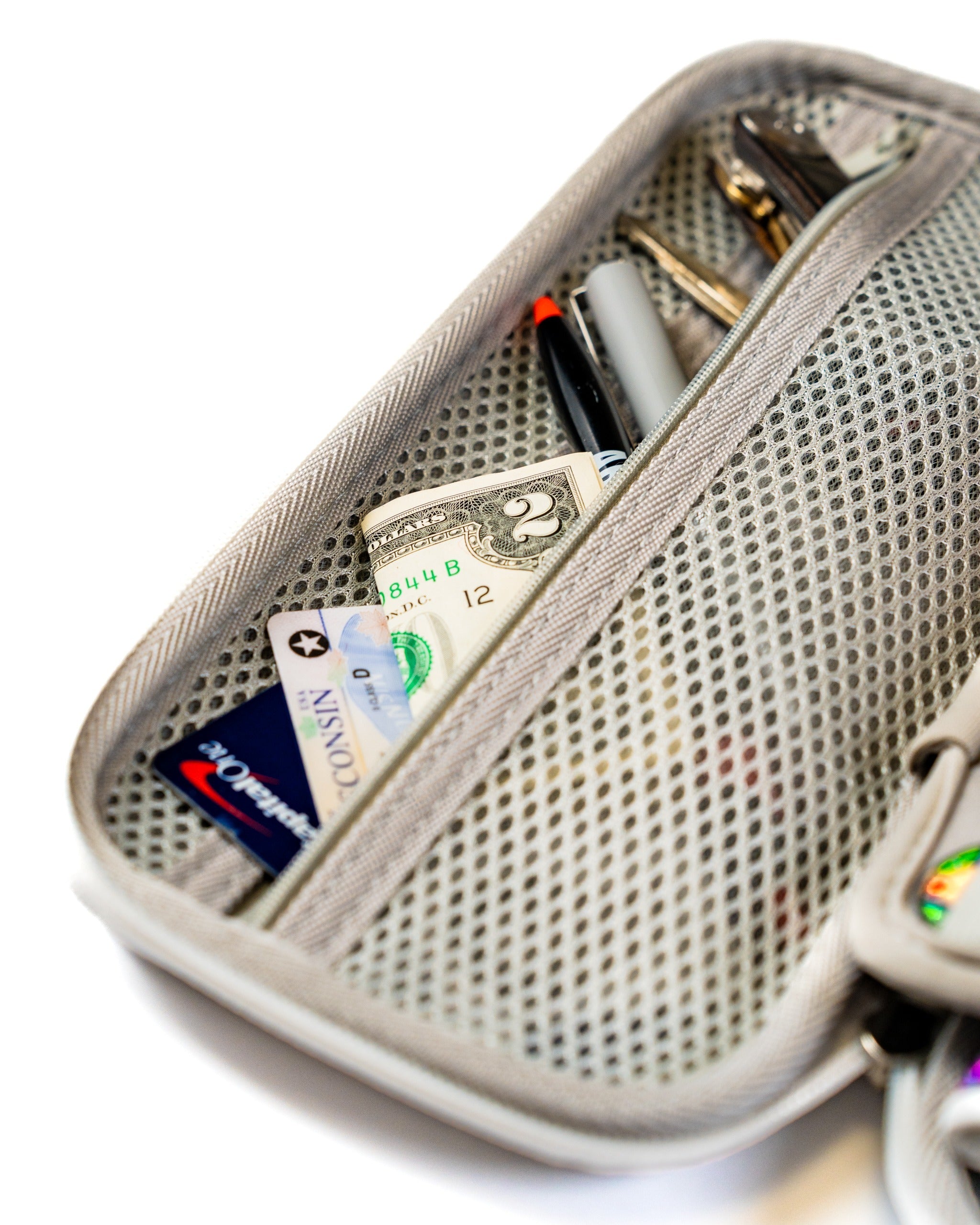 Gray glove and accessory caddie featuring a mesh pocket, holding cash, cards, and pens for organized storage on the golf course.