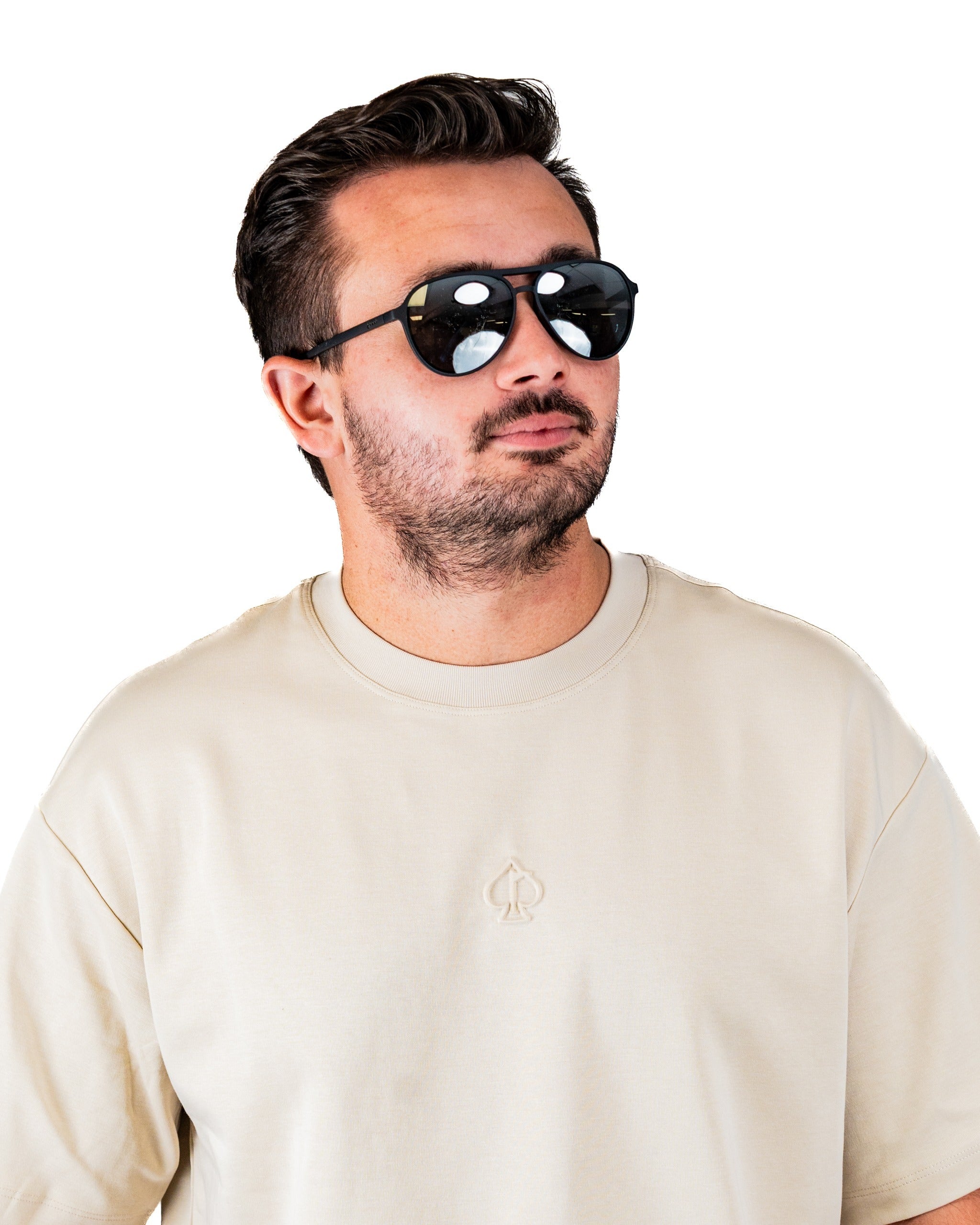 Cream embossed spade tee shirt worn by a man with sunglasses, showcasing a stylish and casual golf look.