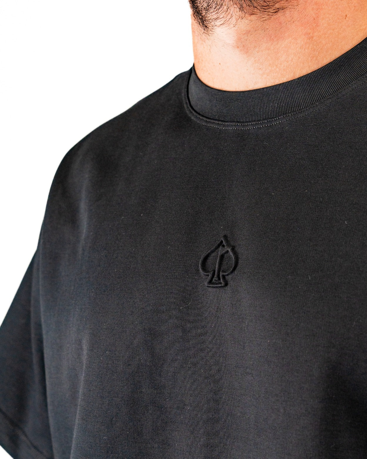 Black embossed spade tee shirt featuring a subtle spade logo on the chest, designed for stylish golfers.