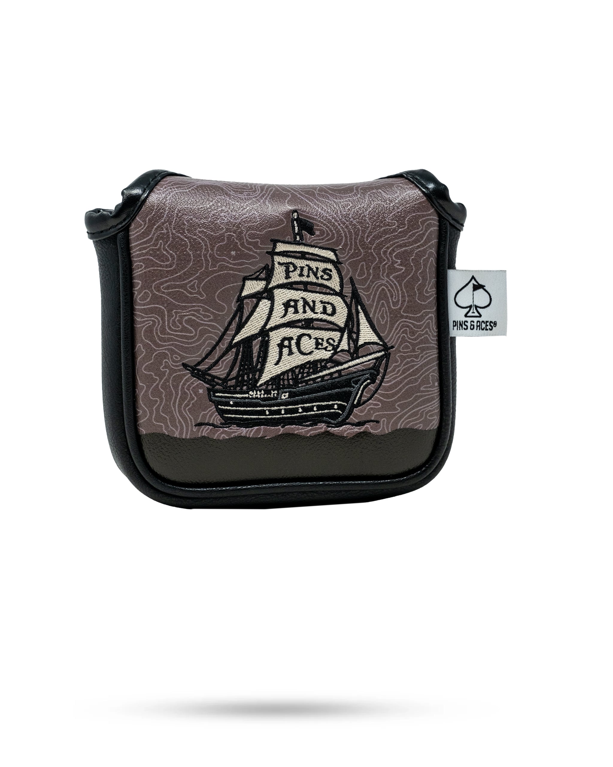 Colorful golf headcover with a pirate ship and "PINS AND ACES" embroidered on sails, black and brown tones, bold and uniqu...