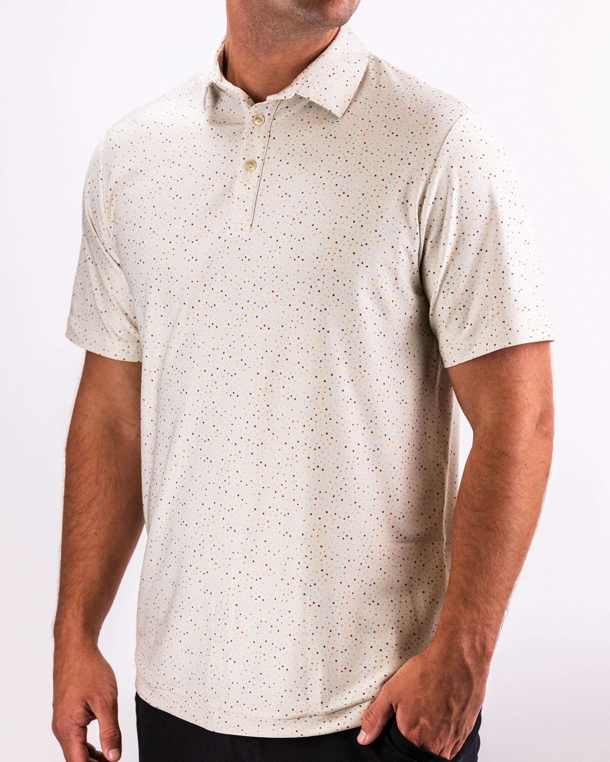 Men's white golf polo with multicolored tiny dot pattern, classic collar, and button placket, perfect for bold golf style.