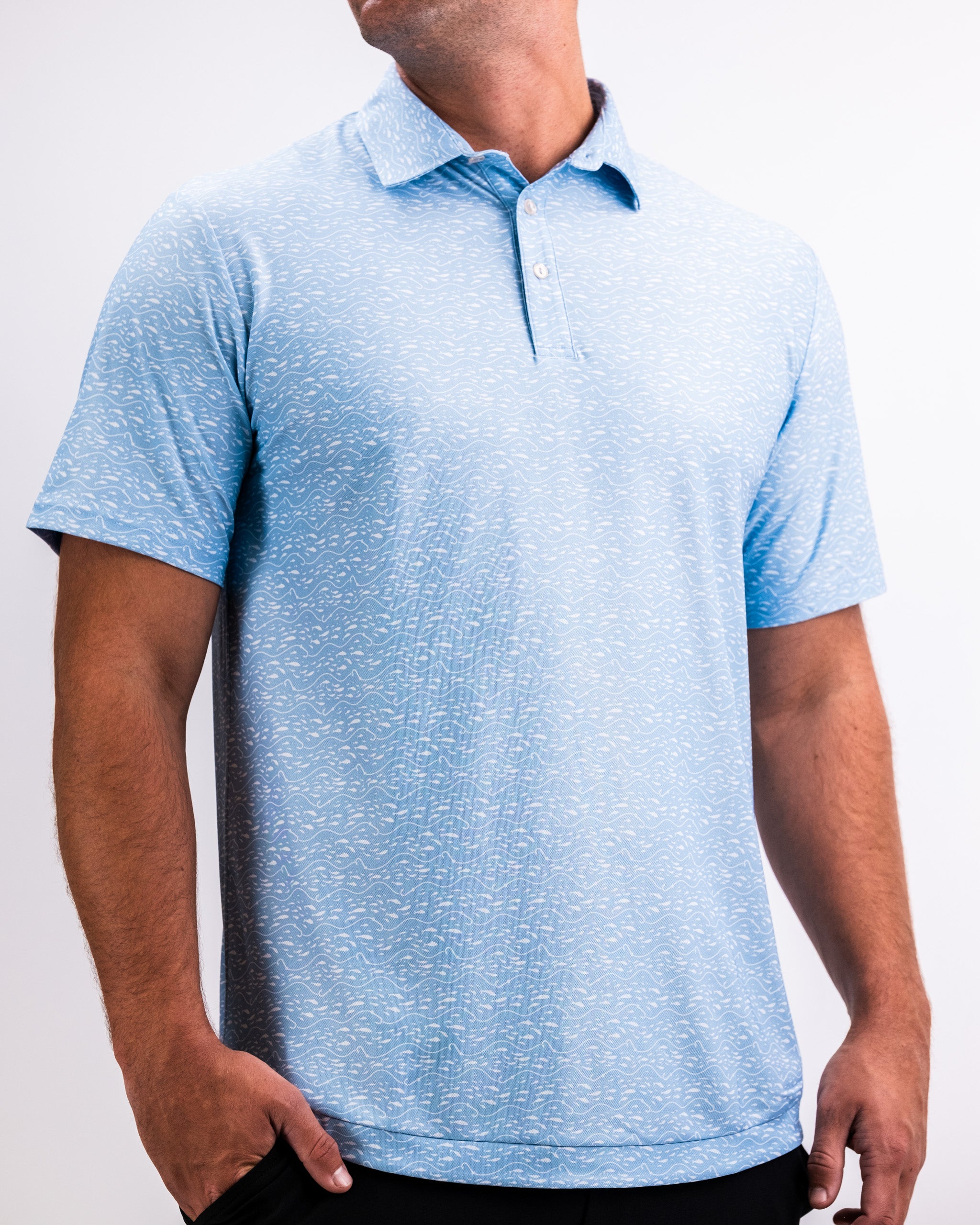 Men's light blue golf polo with a subtle white wave pattern, classic collar, and button placket, perfect for bold golf style.