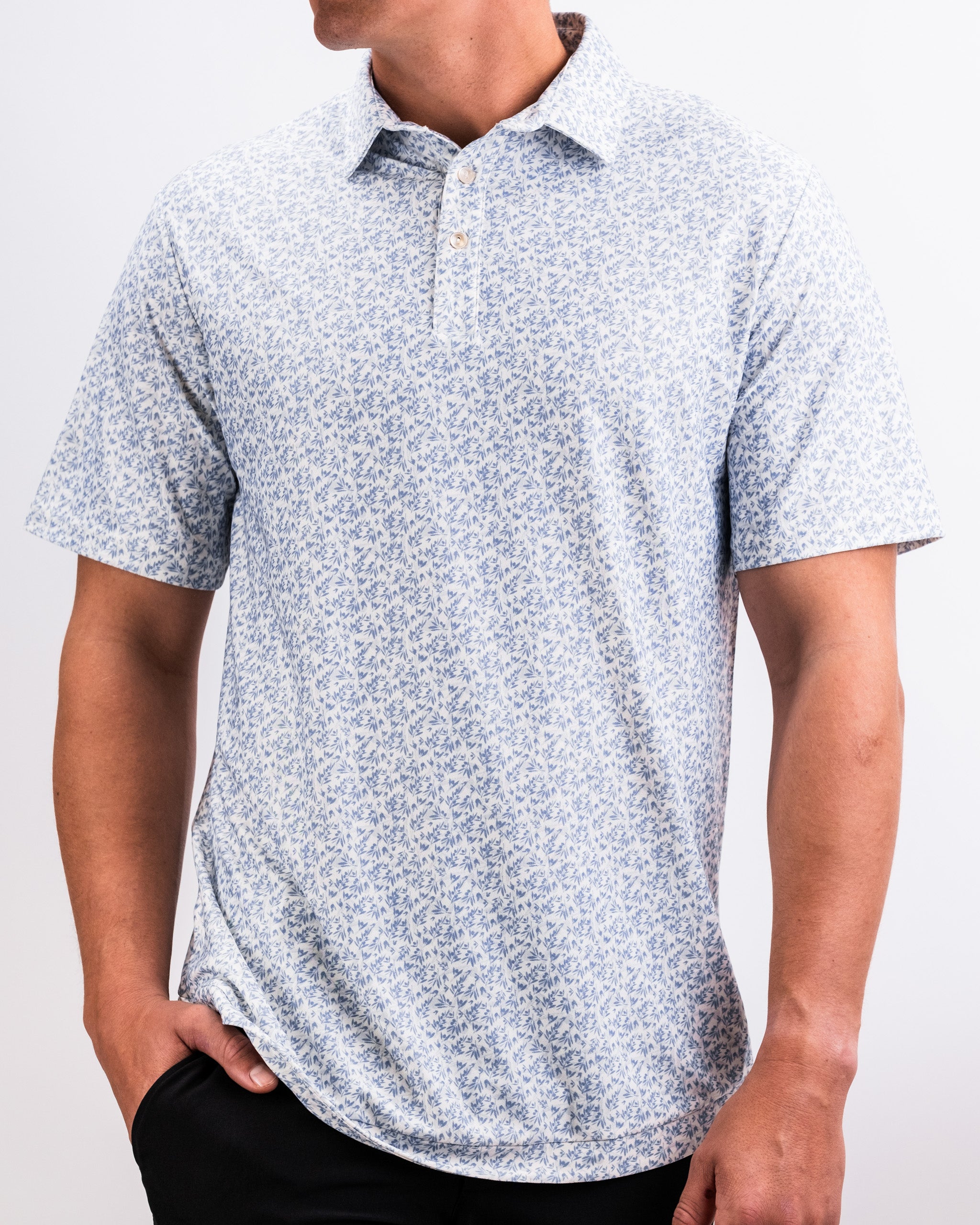 Men's white golf shirt with a blue floral pattern, short sleeves, and collared neckline for bold golf style.