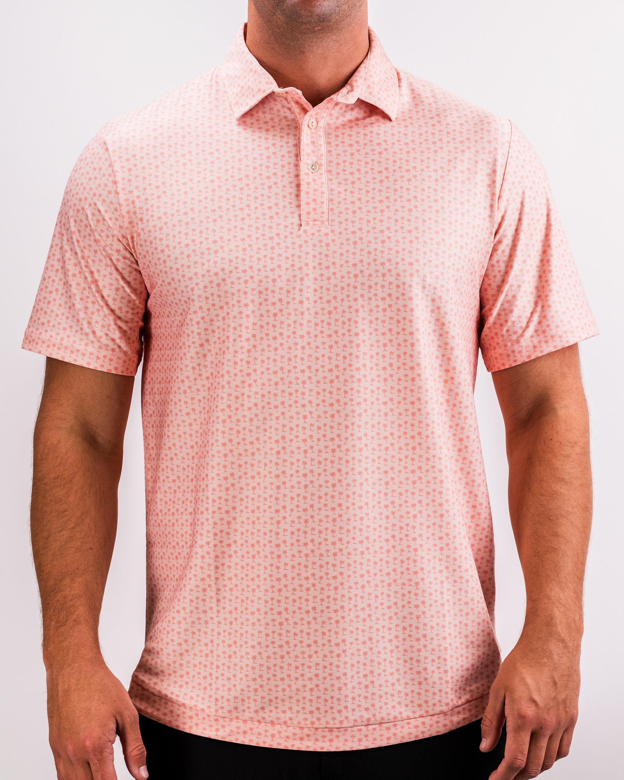 Coral Palms Player Preferred™ Polo featuring vibrant palm leaf pattern on a lightweight fabric.