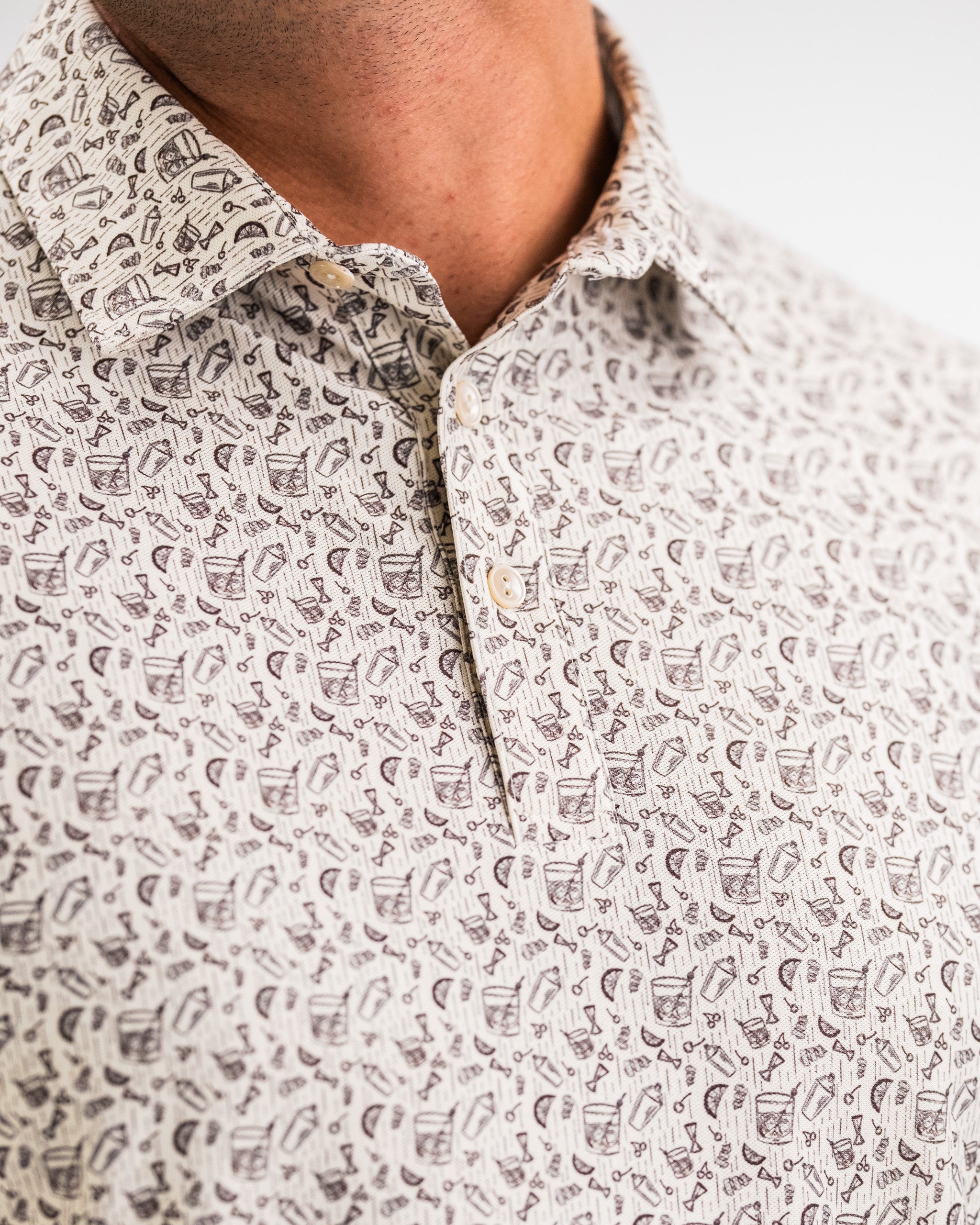 Close-up of a white golf shirt with black abstract print, button-down collar, perfect for bold golf apparel.