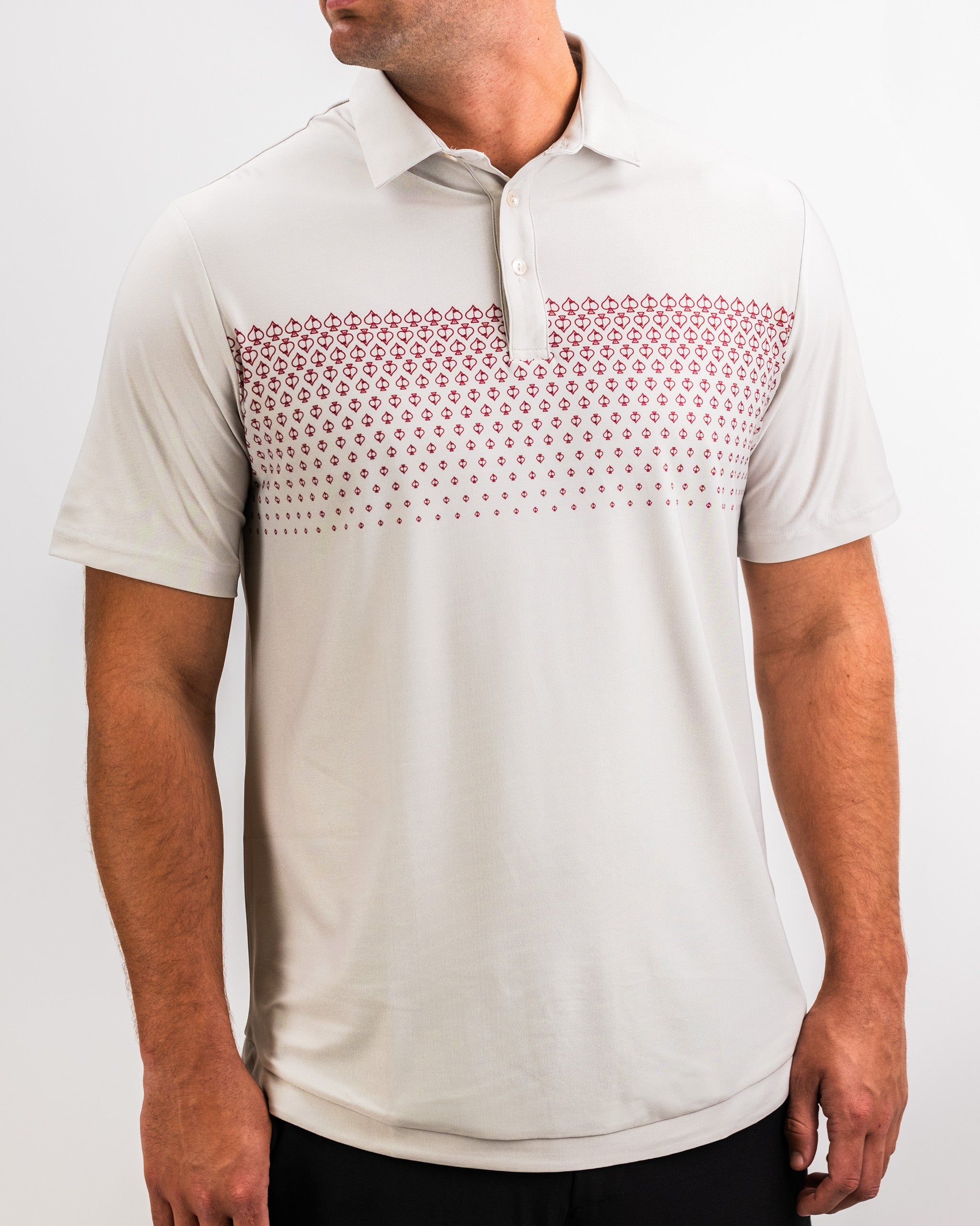 White golf polo with red geometric pattern across the chest and shoulders, featuring a classic collar and button placket.