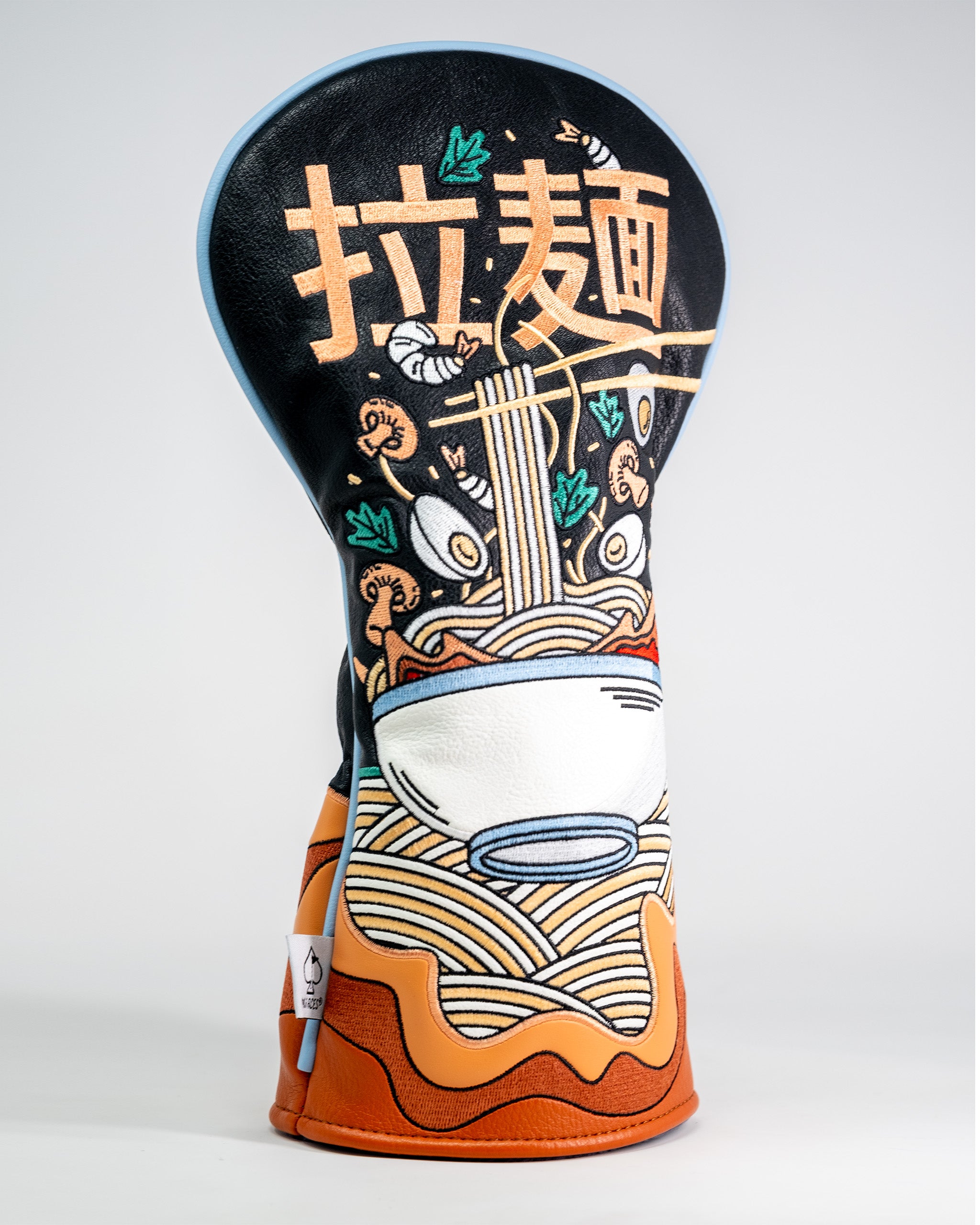 Golf driver cover featuring a colorful ramen bowl design with noodles, chopsticks, and vegetables on a black background.