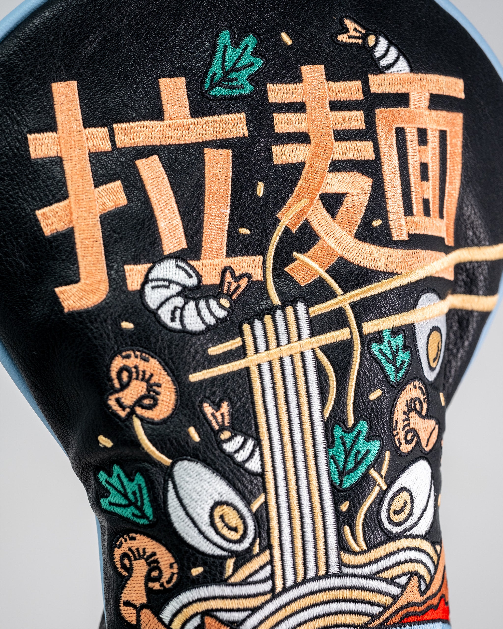 Embroidered driver cover featuring a ramen bowl with noodles, eggs, shrimp, and chopsticks on a black background.
