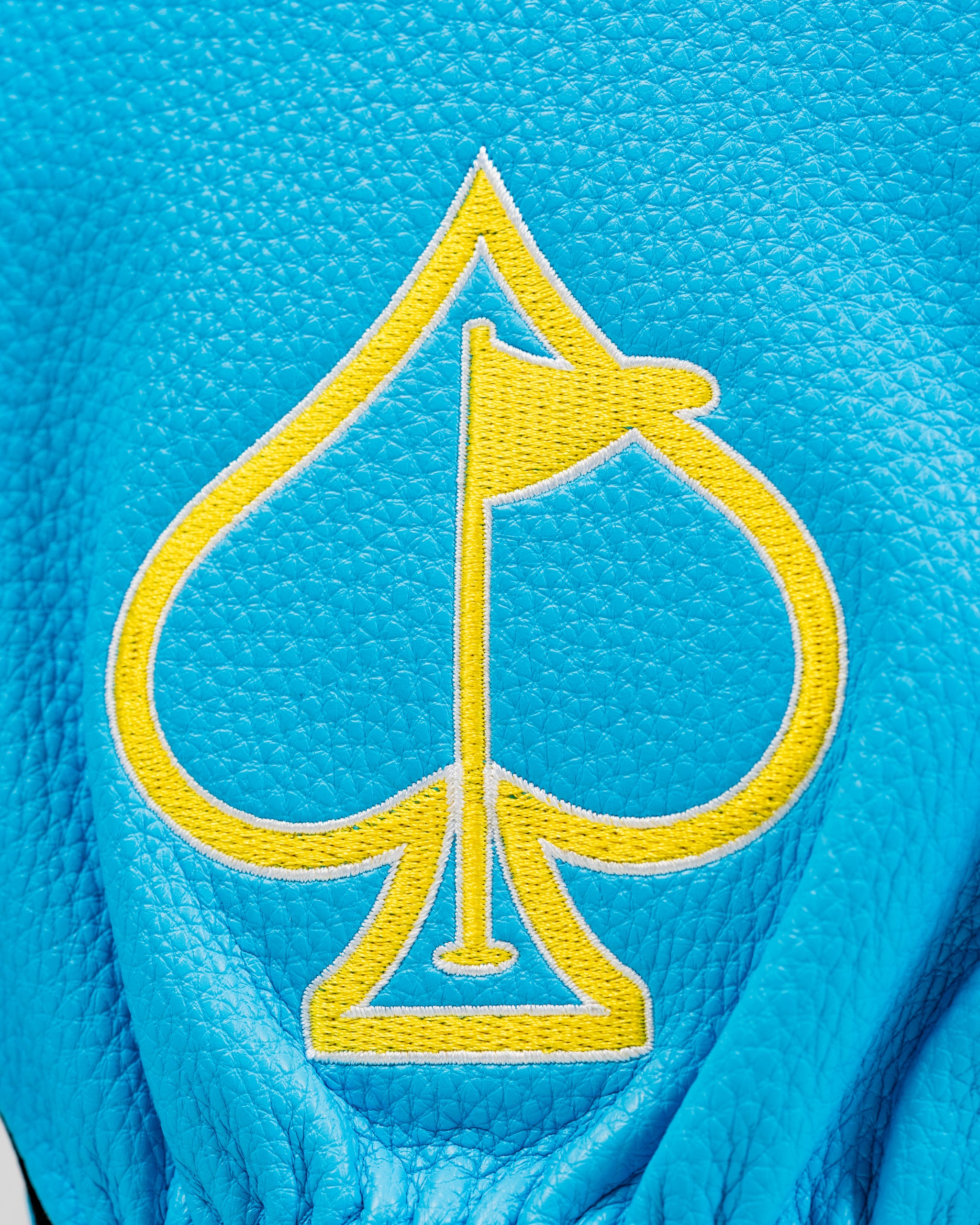 Bright blue driver cover featuring a yellow spade logo with a flag, designed for golfers seeking stylish accessories.