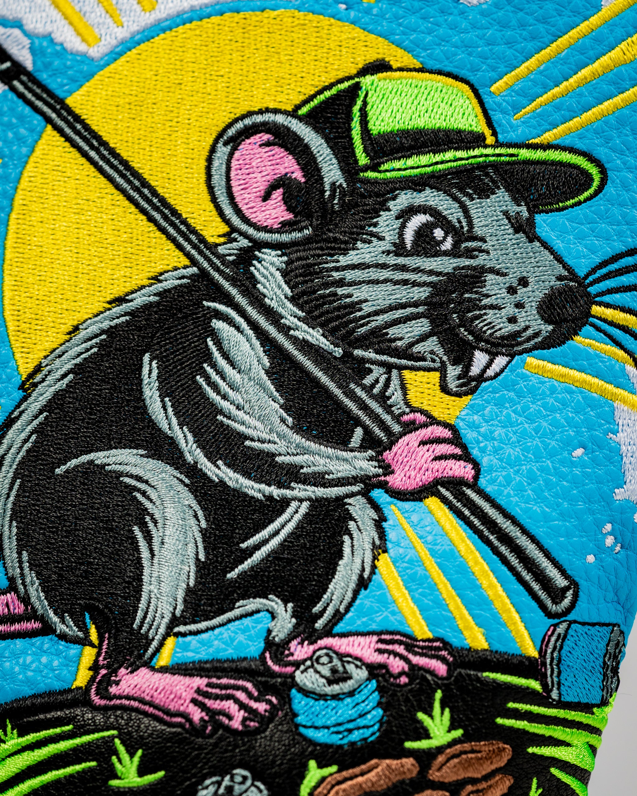 Colorful driver cover featuring a cartoon rat in a cap, holding a golf club with vibrant embroidery and playful details.