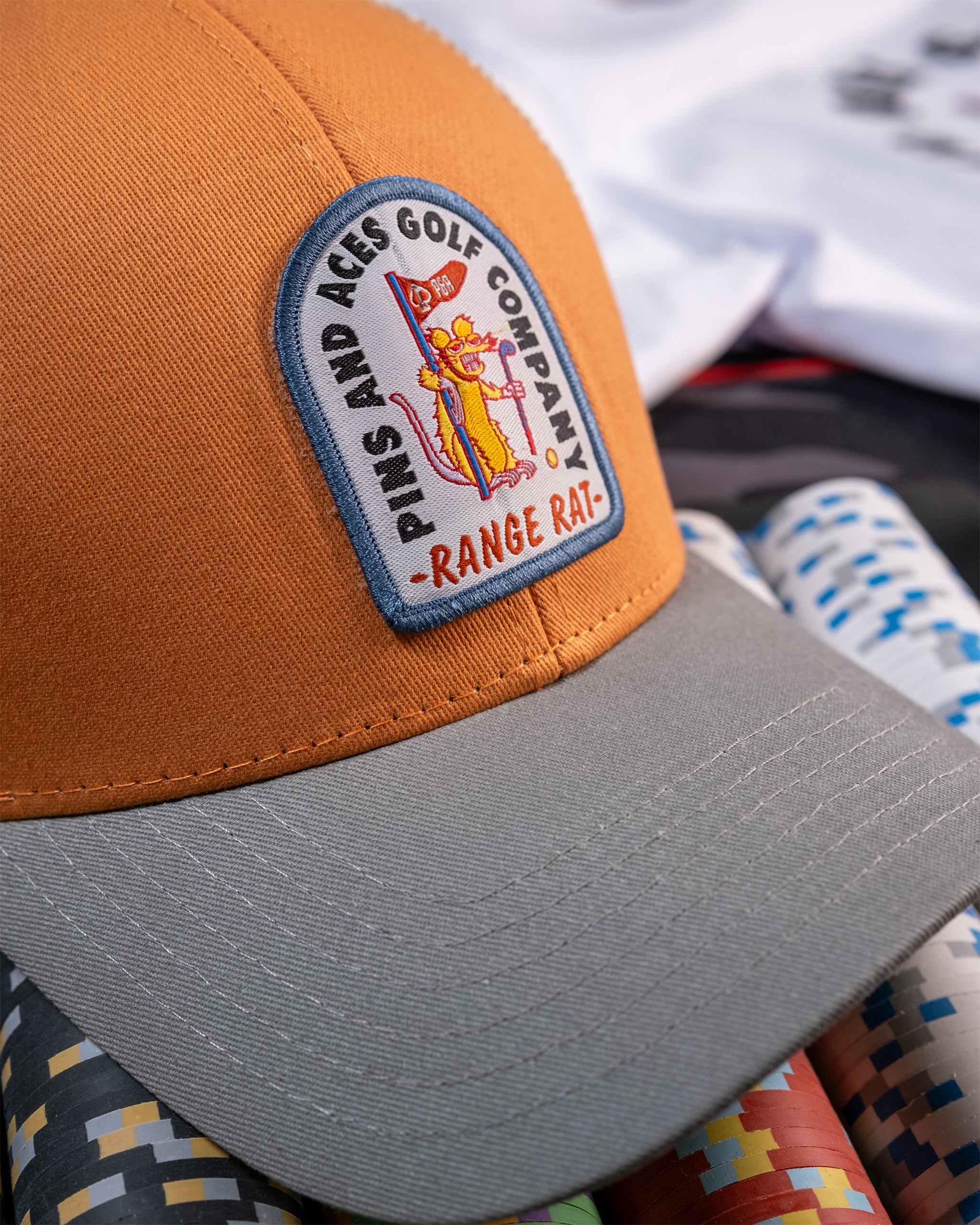 Trucker hat in vibrant orange with a mesh back and 'Range Rat' graphic design.