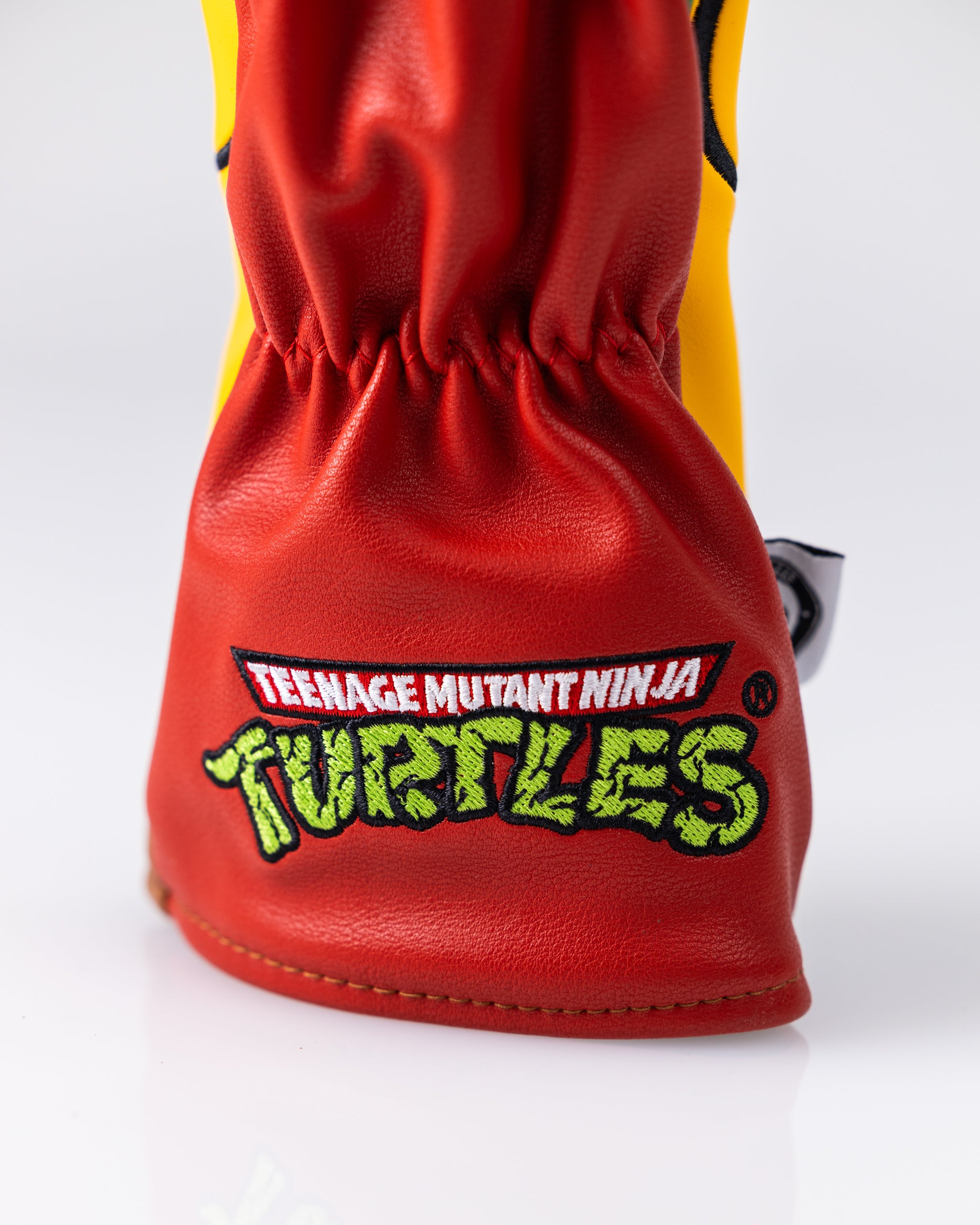 Red Teenage Mutant Ninja Turtles-themed golf headcover with embroidered logo, bold colors, and textured faux leather design.