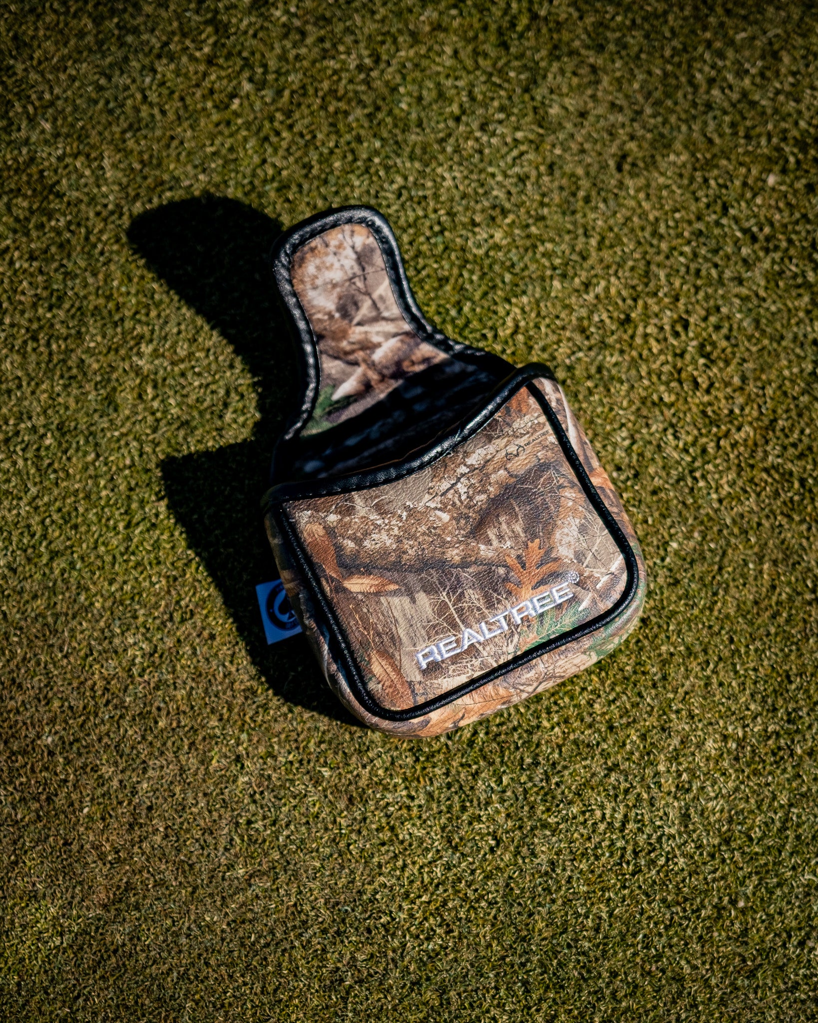 Realtree camo mallet cover displayed on a green background.