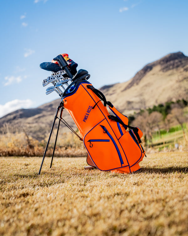 Player Preferred™ Golf Bag in vibrant orange, featuring multiple pockets and a sleek design, ideal for golfers.
