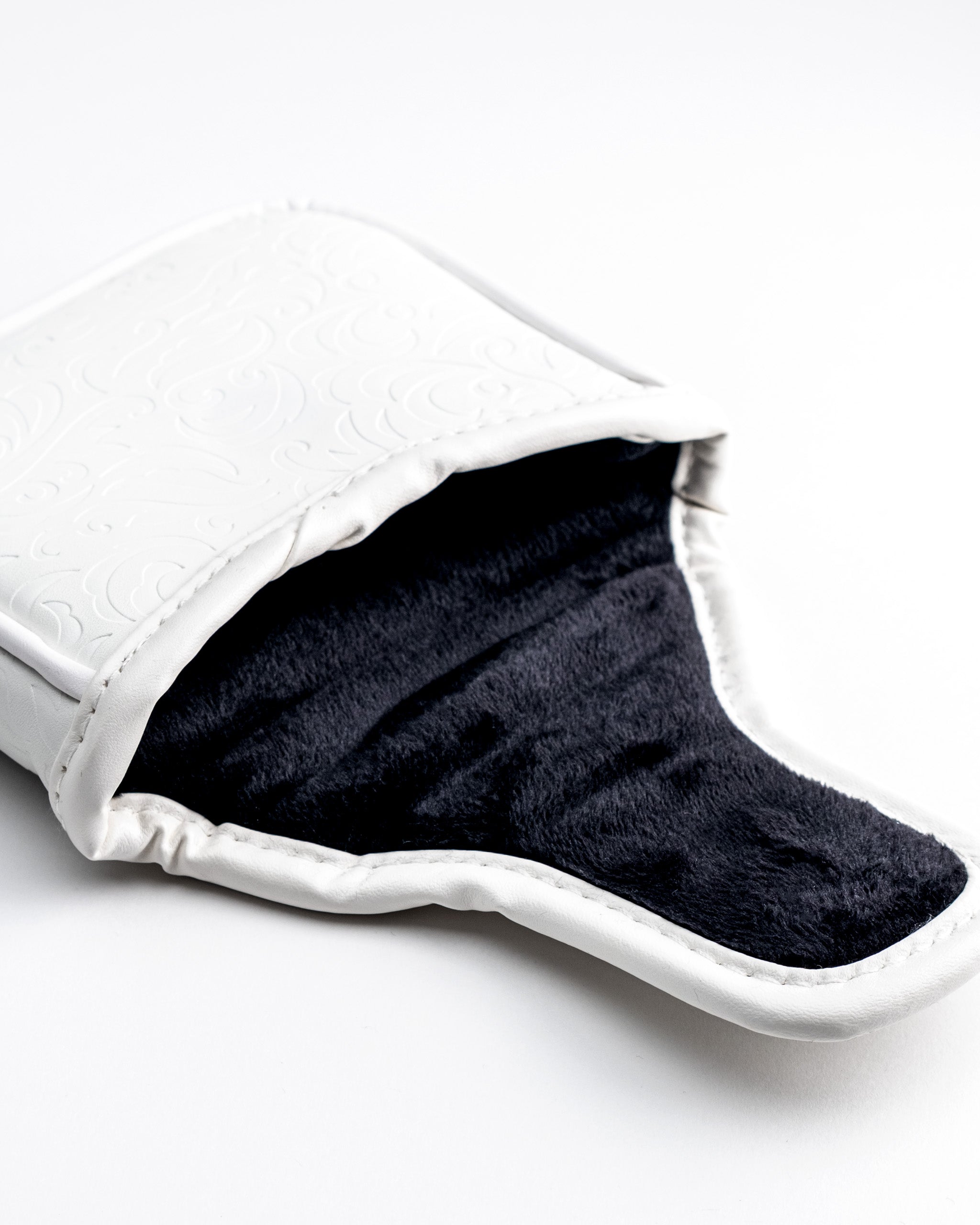 White golf club headcover with embossed swirl pattern and black plush interior, bold style for standout golfers.