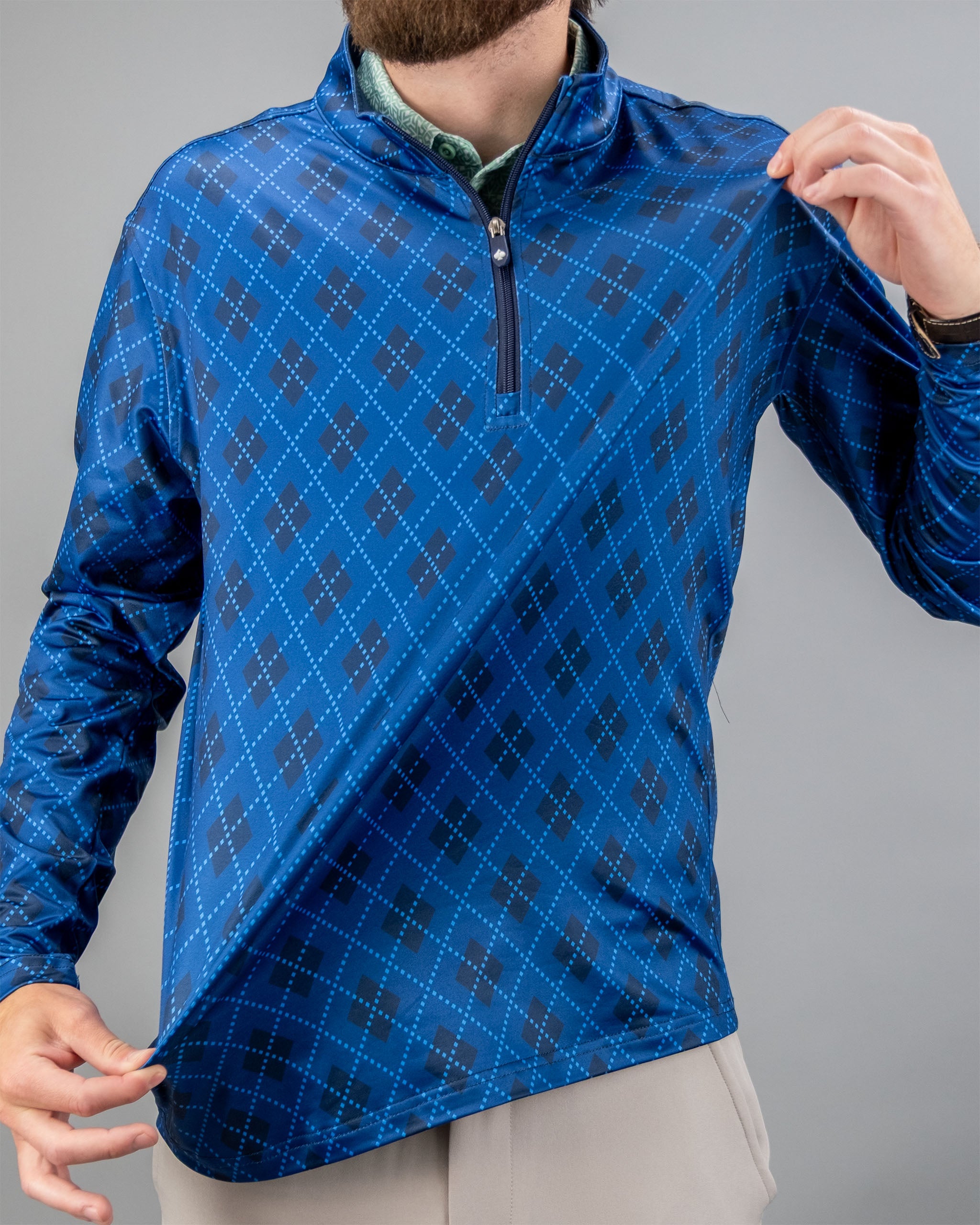 Windsor Blue pullover with a quarter zip and diamond pattern, showcased by a model pulling the fabric.