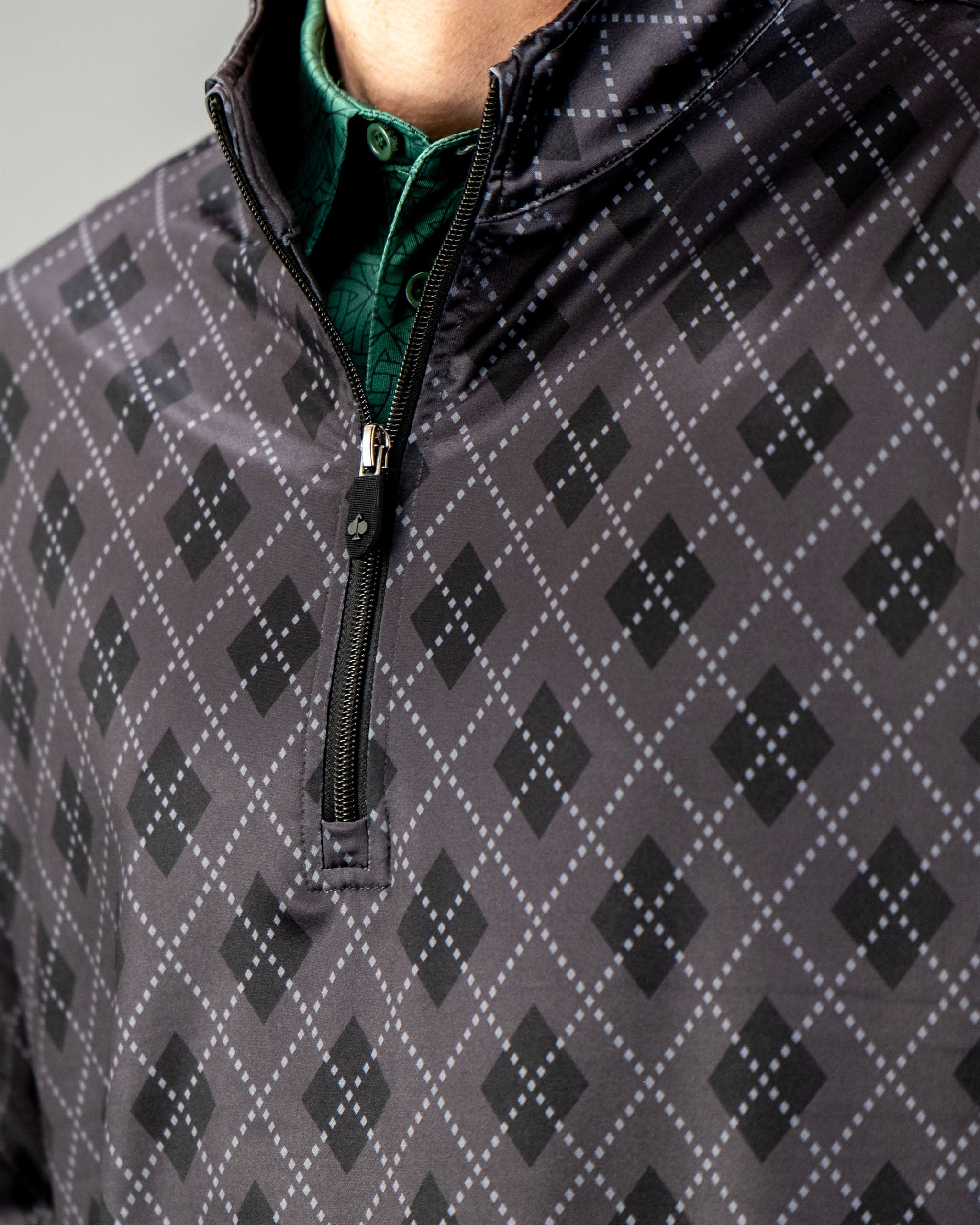 Close-up of a London Fog pullover featuring a geometric pattern and a quarter zip design, showcasing a stylish look.