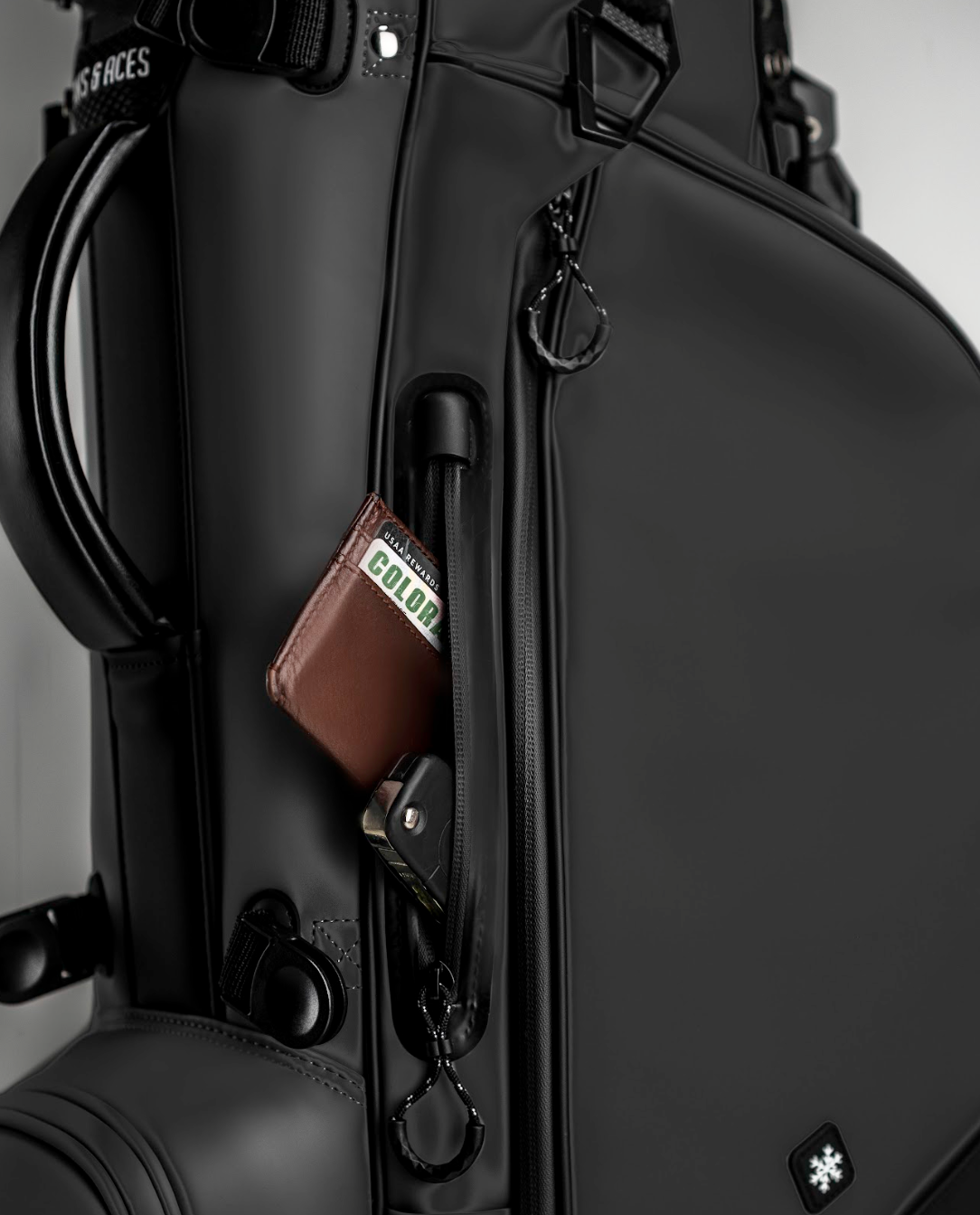 Black golf bag with brown wallet and accessories, featuring a bold, modern design for golfers who want to stand out.