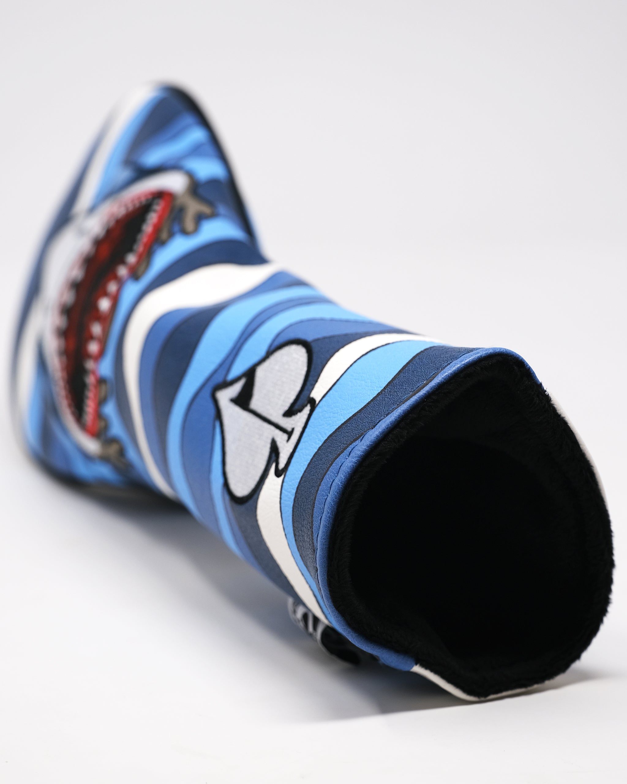 Colorful golf headcover with bold blue, black, white stripes, and cartoon-style logo, designed for stand-out golf style.