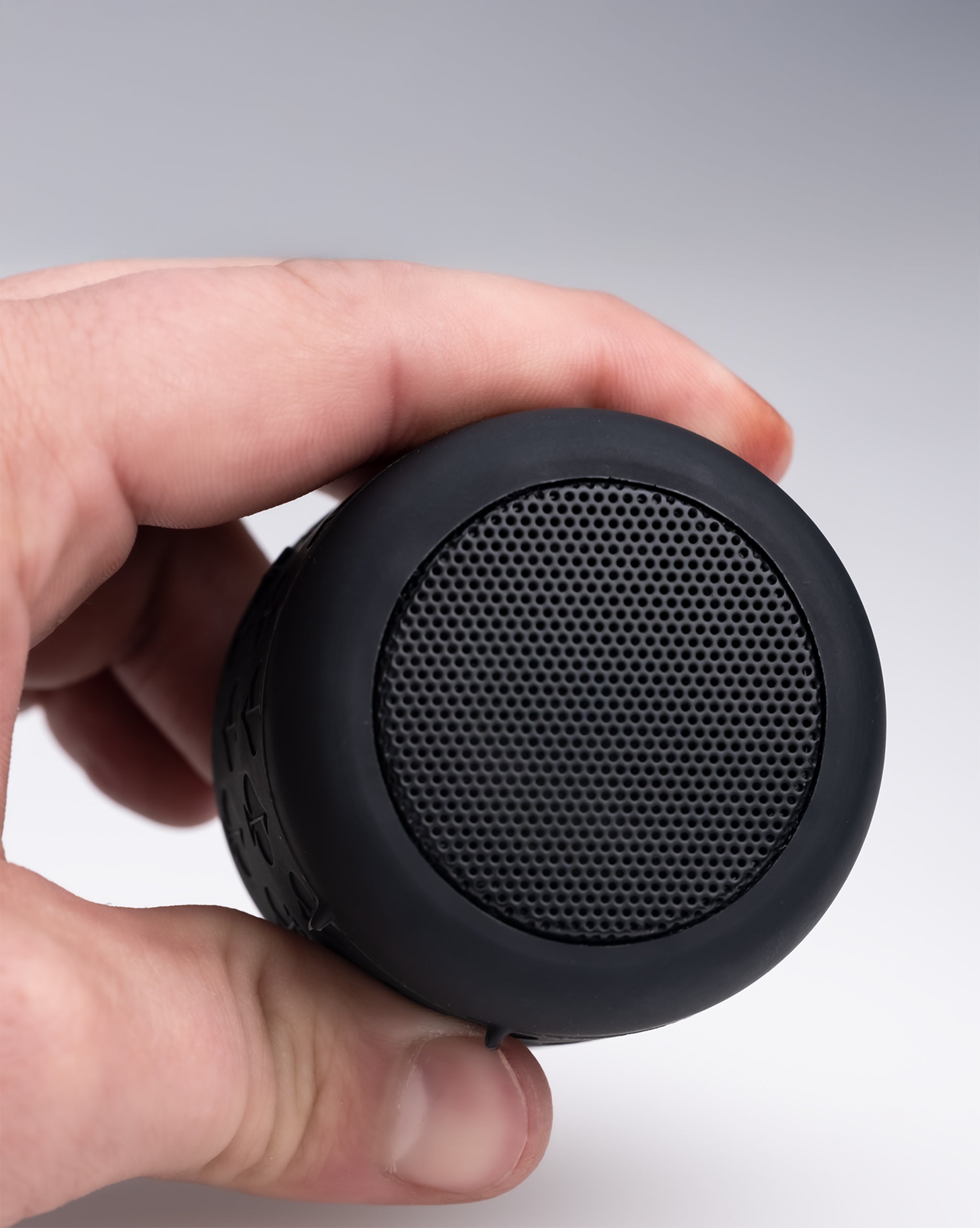 Black portable Bluetooth speaker with a round, textured grille and rugged design, perfect for bold golf accessories.