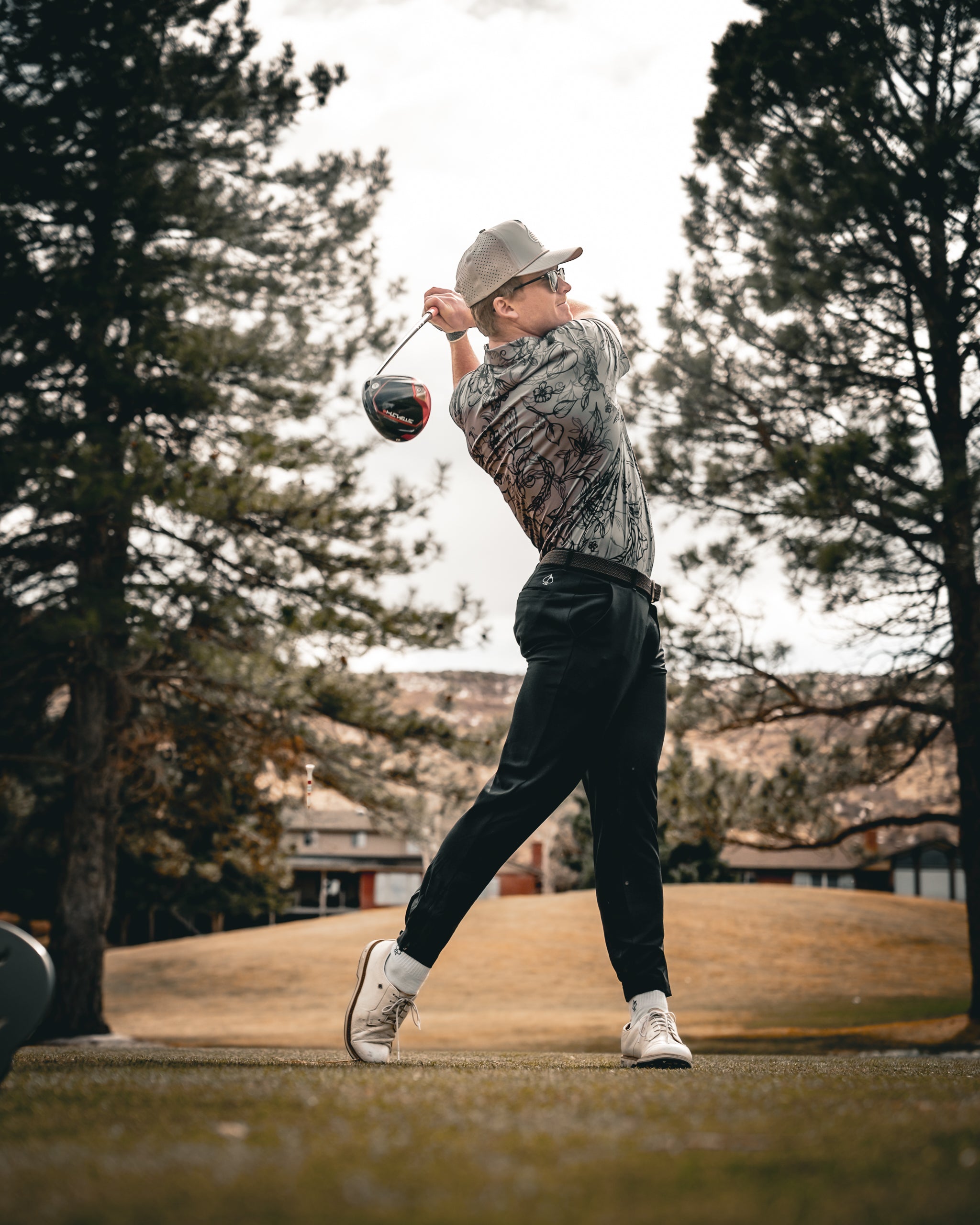 Cabo Midnight casual outfit featuring a navy blue shirt, white pants, and stylish accessories, displayed in a chic outdoor setting.