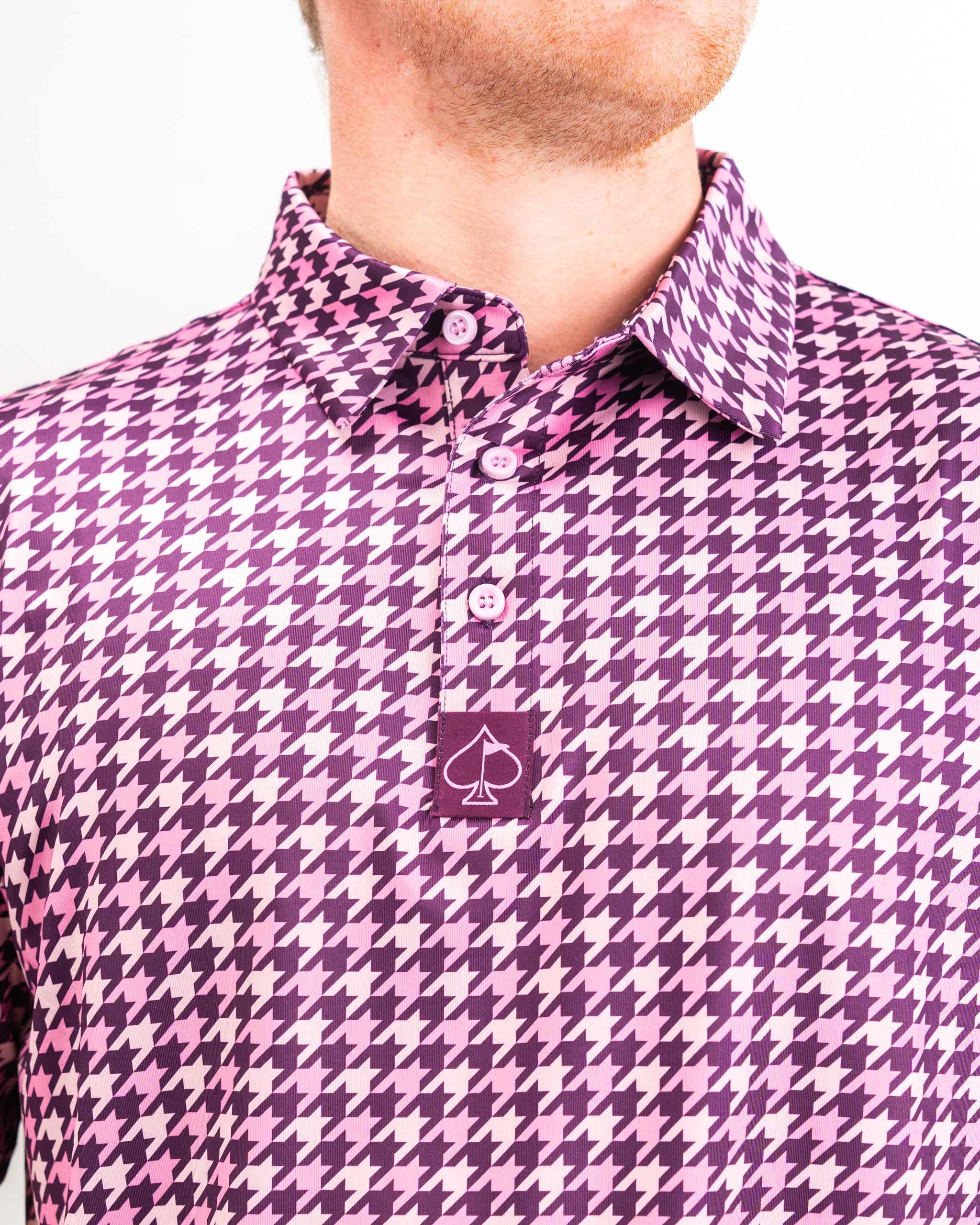 Houndstooth-patterned fabric in raspberry color, displaying texture and style for a fashionable menswear option.