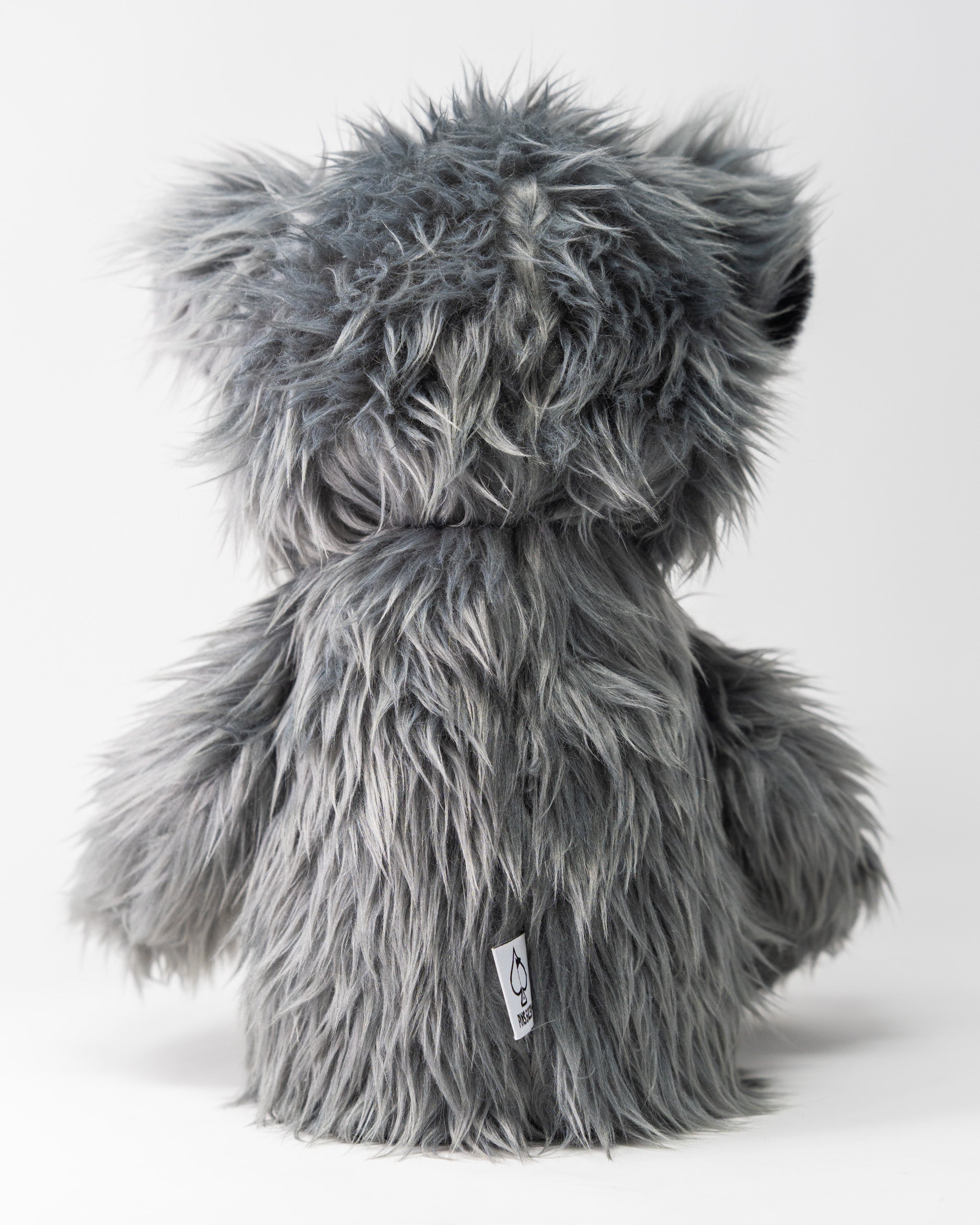 Gray faux fur driver cover in the shape of a cute, fluffy koala with a tag, designed to protect golf club drivers.