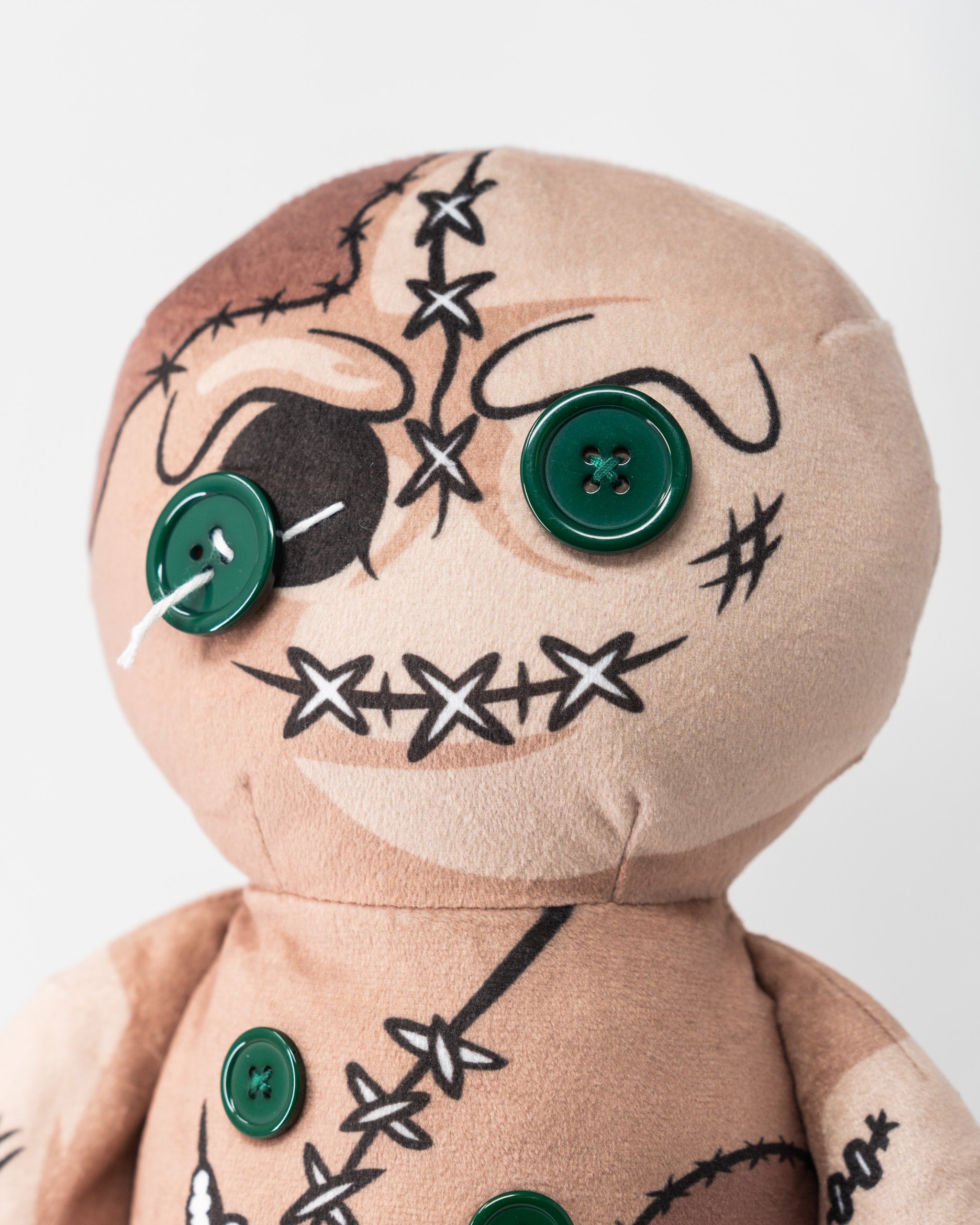 Soft plush Voodoo Doll driver cover with stitched face, black markings, and green buttons for eyes and body details.