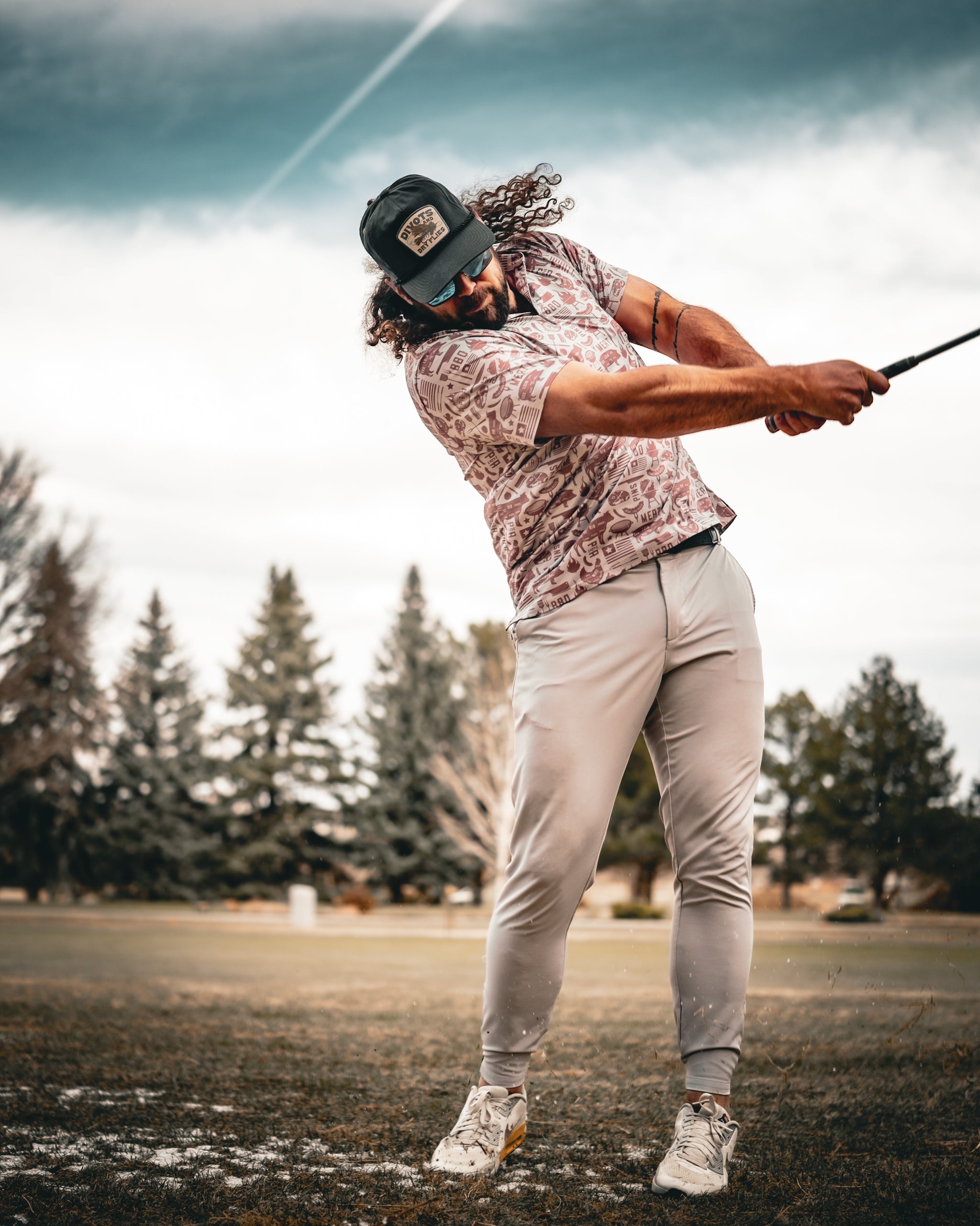 Pitmaster grilling on a barbecue with smoky background, wearing an apron, and holding grilling tools, showcasing outdoor cooking and BBQ lifestyle.