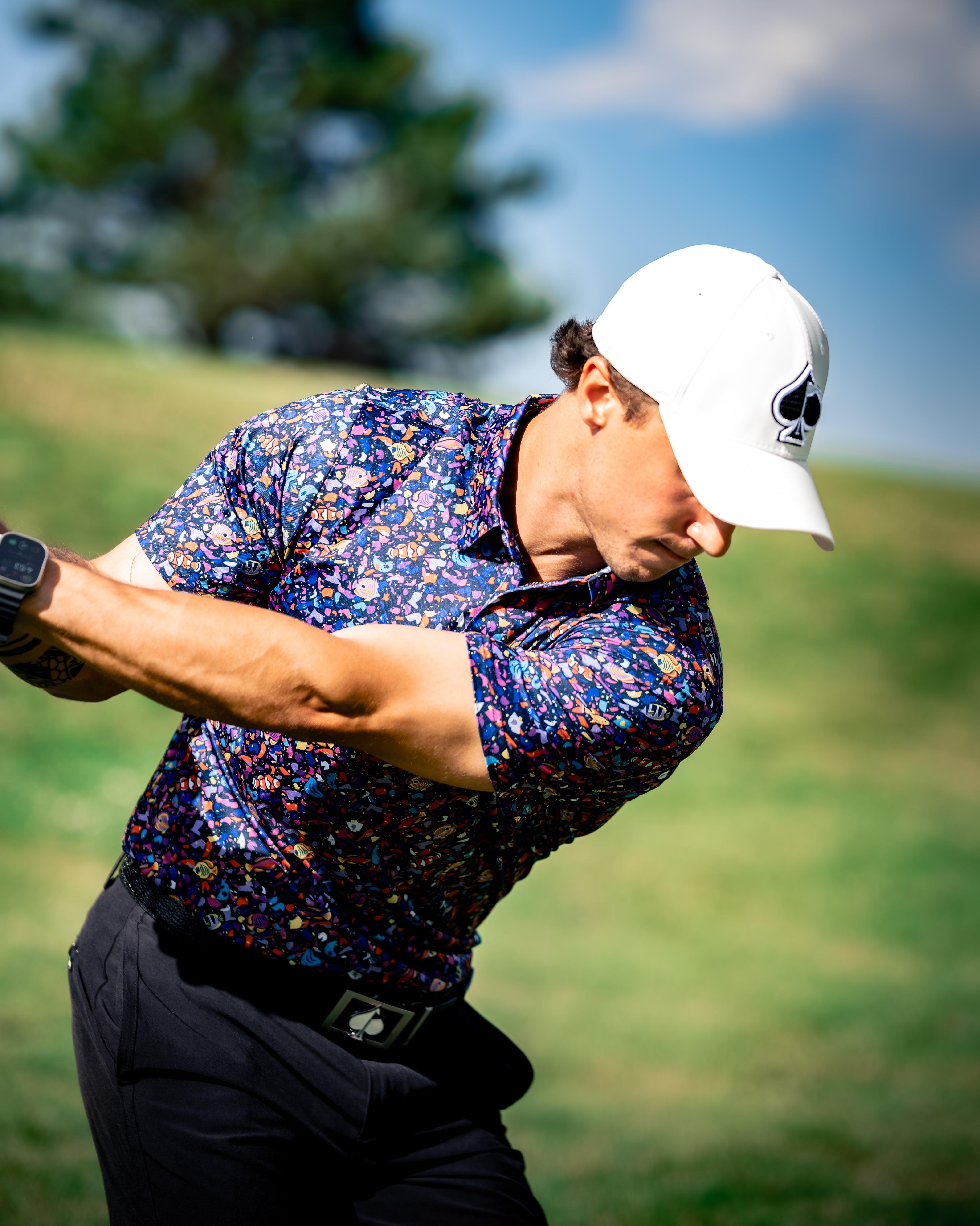 Raspberry Houndstooth Tropical Shatter hoodie displayed on a model outdoors, showcasing vibrant colors and stylish design.
