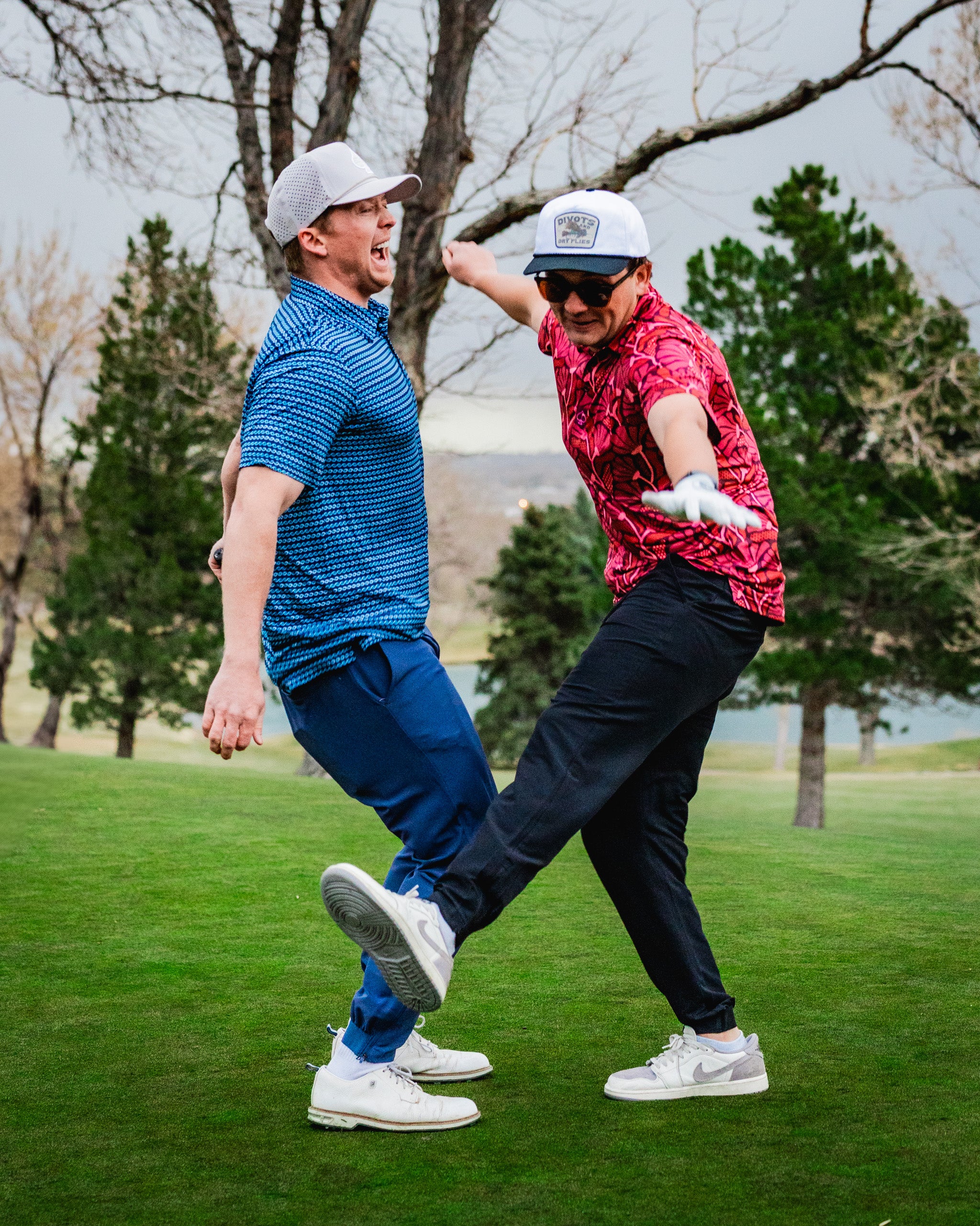 alt="Garden Party Crimson Bloom floral arrangement featuring vibrant red and pink flowers in a lush green garden setting."