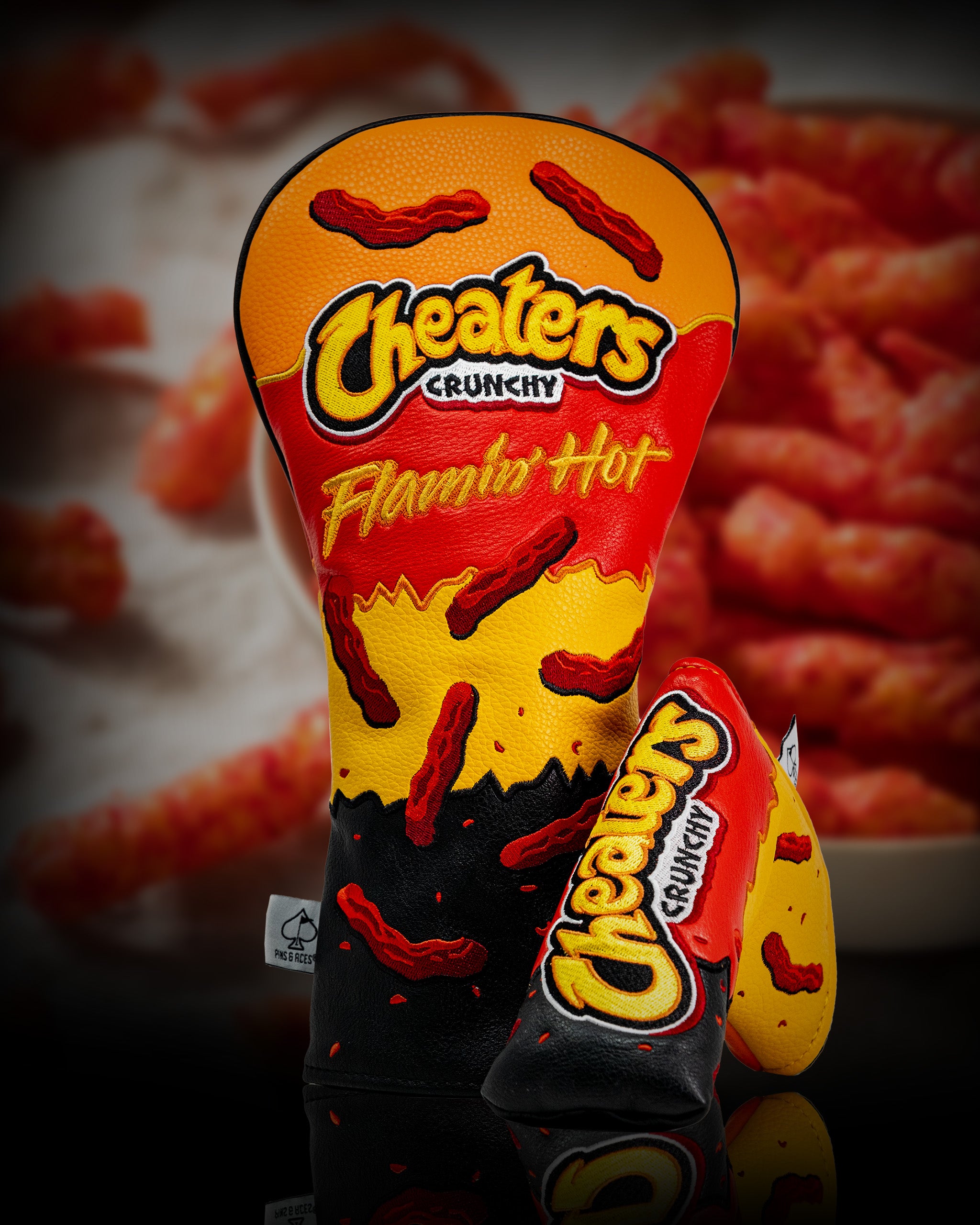 Golf driver cover featuring a Cheaters Flamin' Hot snack design with red hot pepper illustrations and bold colorful branding.