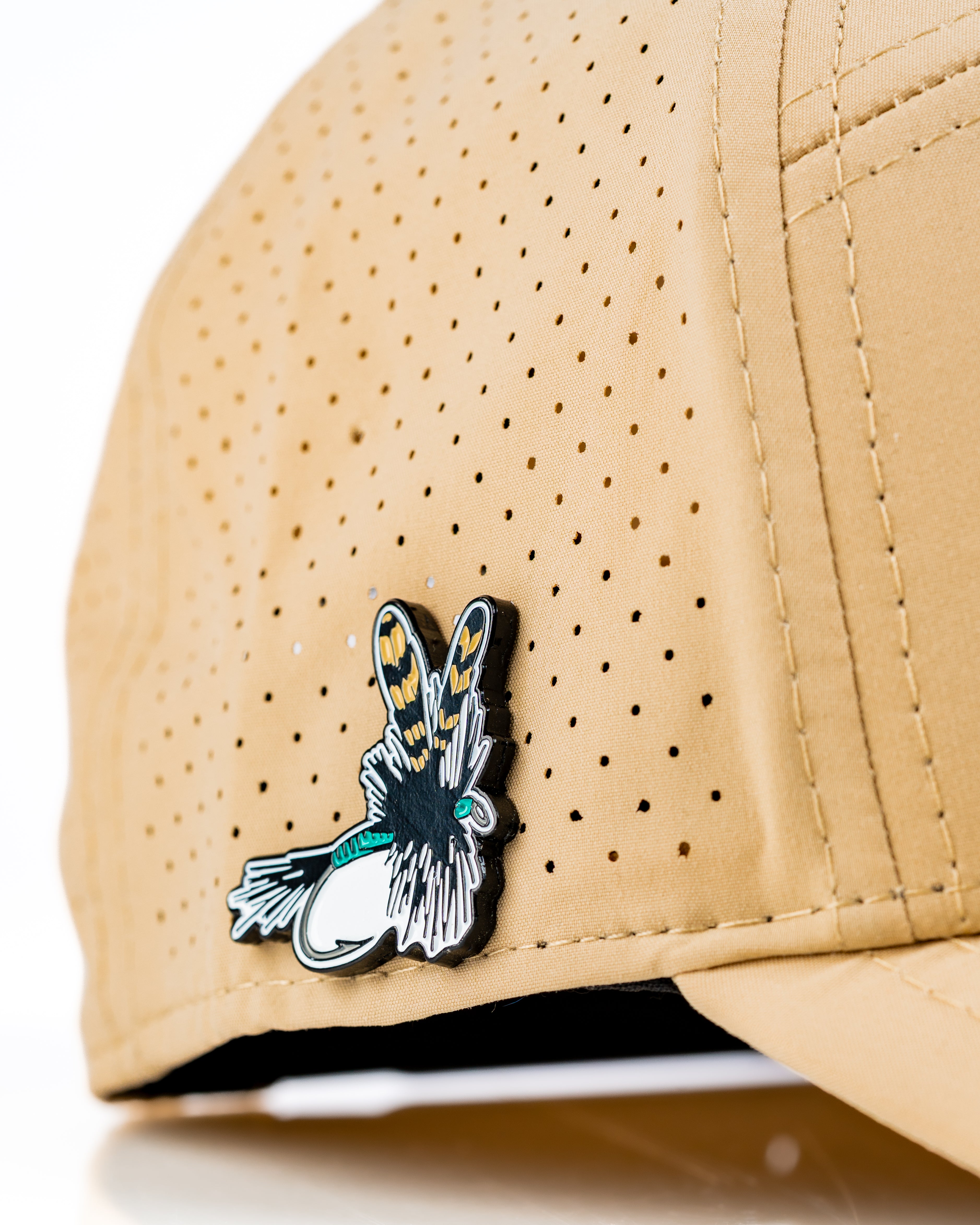 Stylish Tradesman Hat in Dry Fly color featuring a unique fly design pin and breathable perforated fabric.