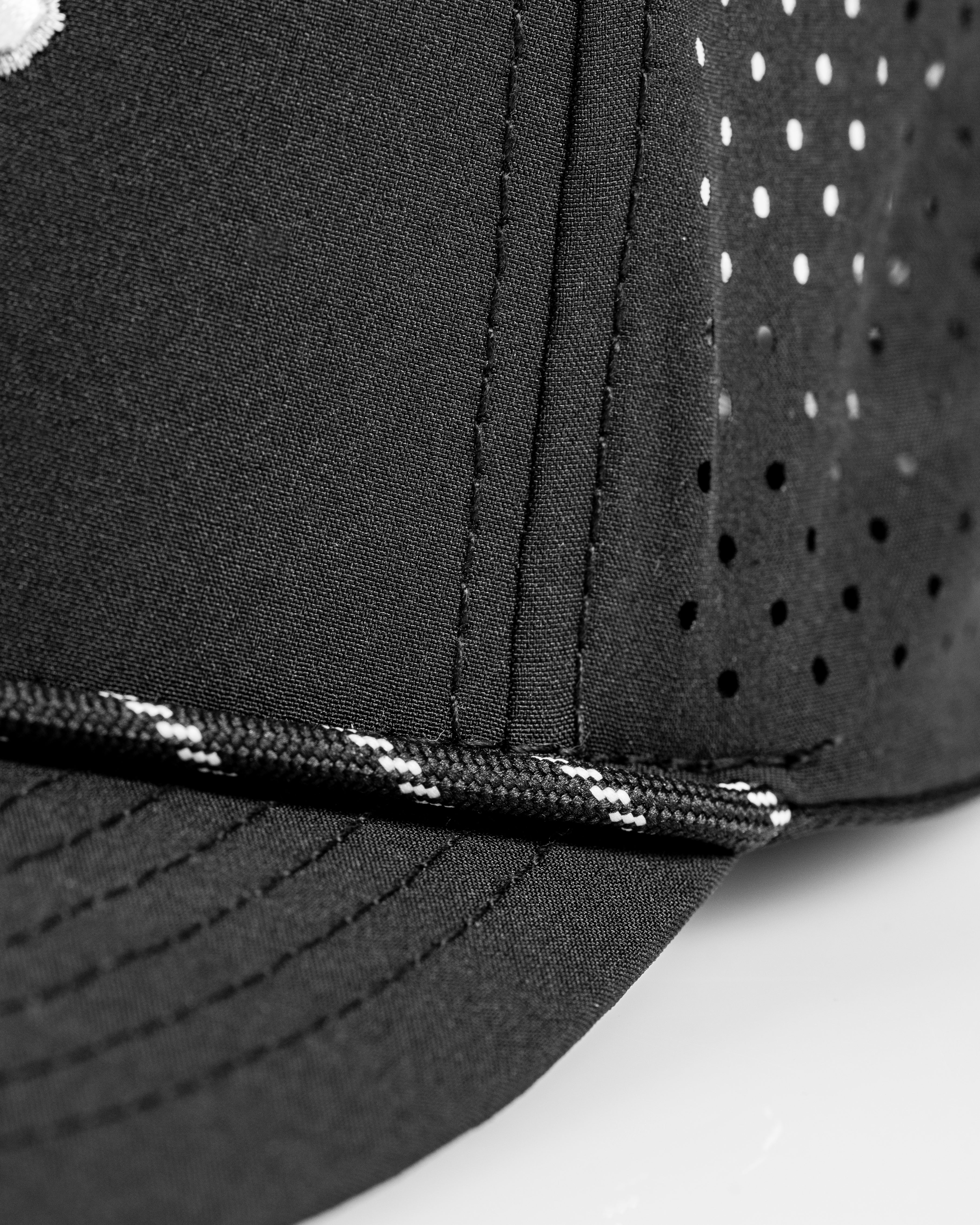 Perforated Rope Hat in black features a stylish design with ventilation holes and a unique rope detail along the brim.