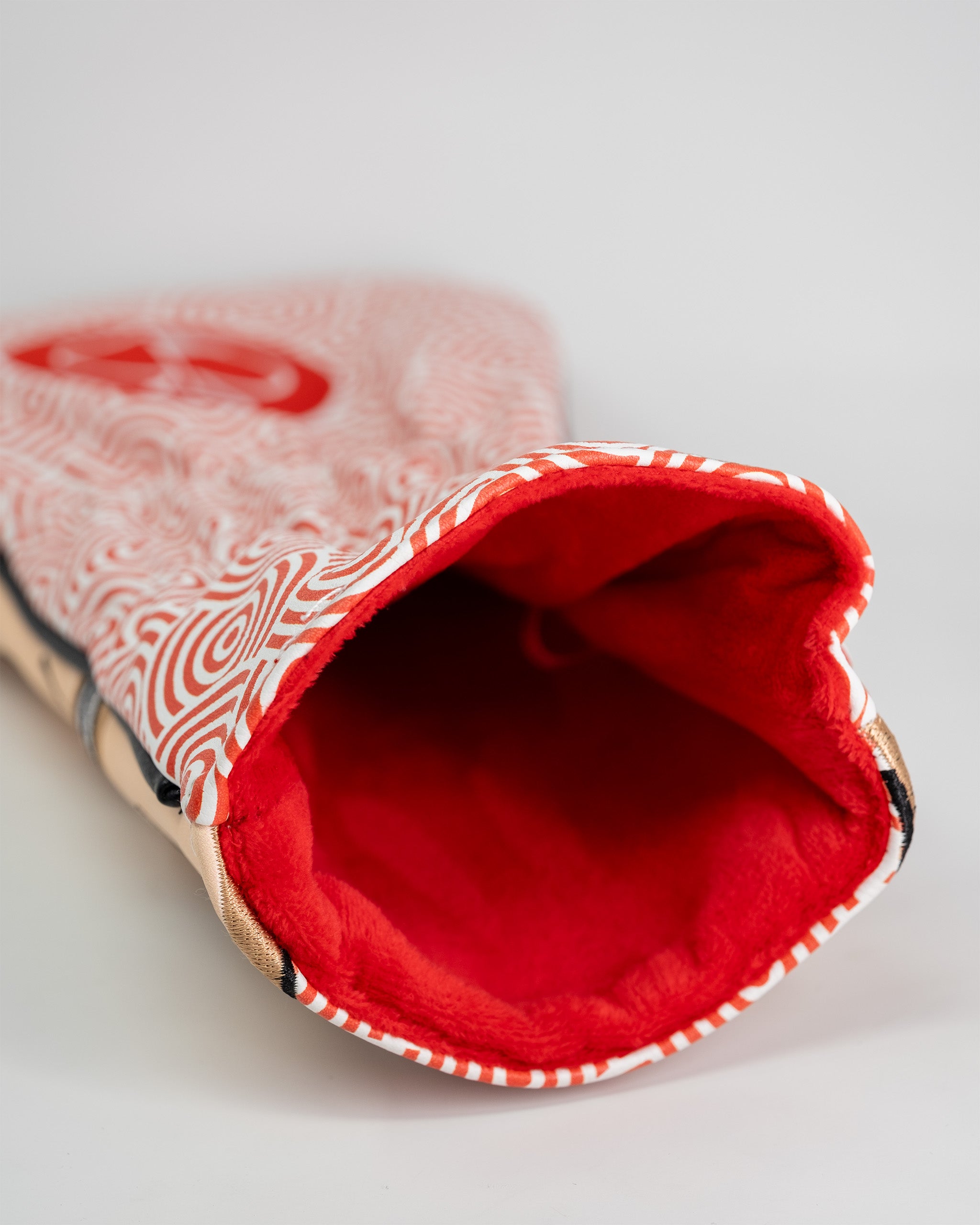 Red and white patterned golf driver cover with a soft red fleece interior, designed to protect golf club drivers.